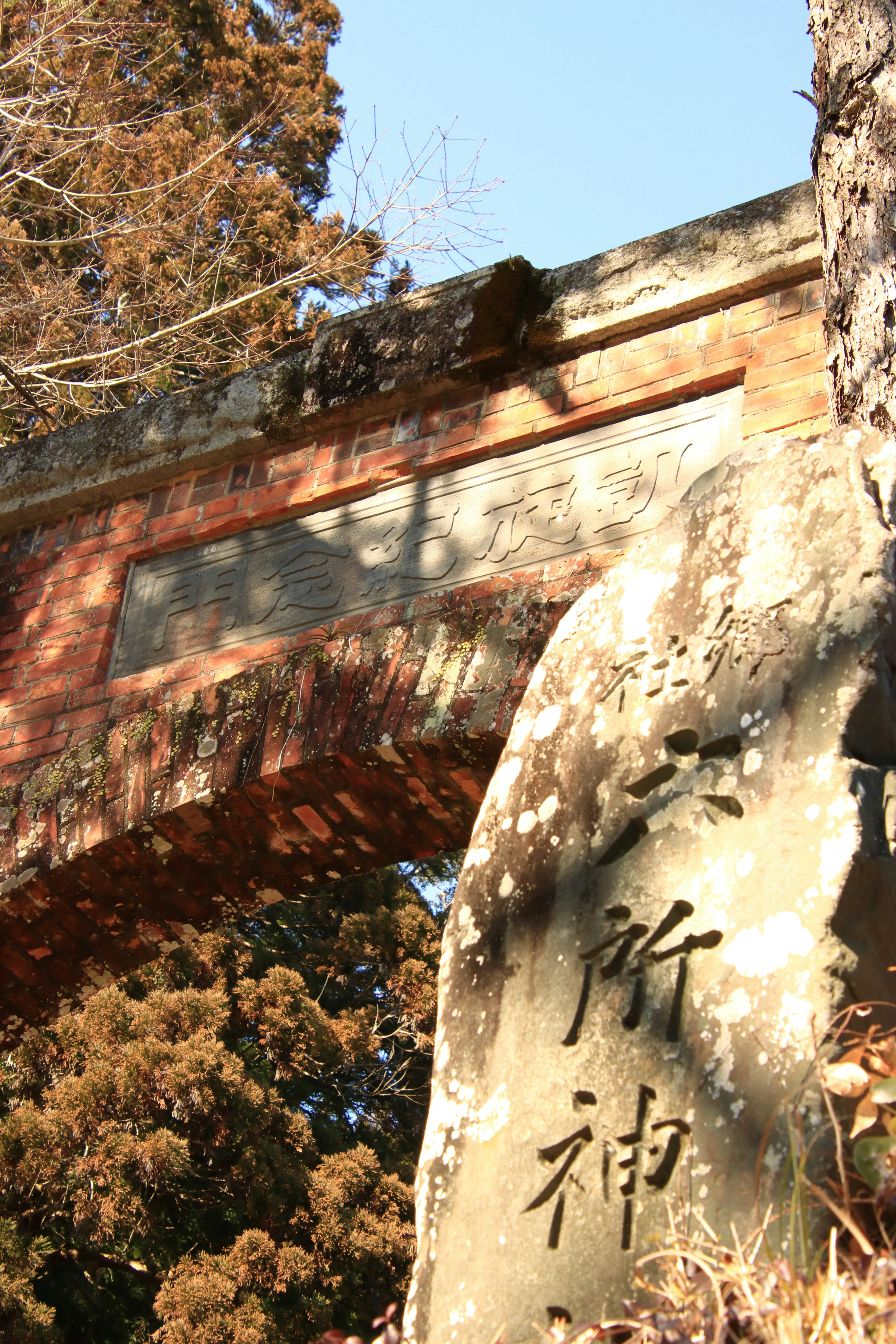 Scenic view of a shrine featuring a red torii gate and a stone monument