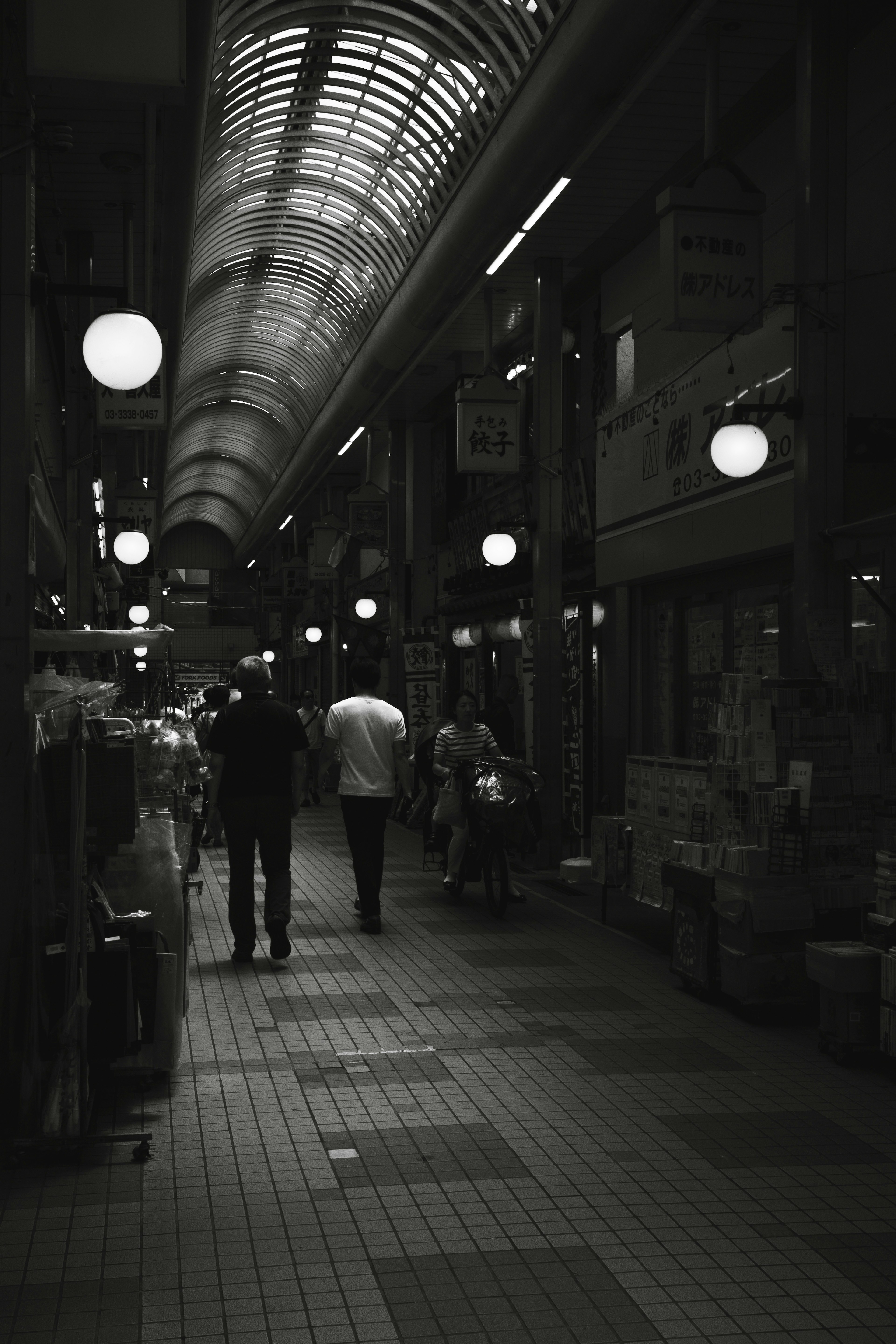 Persone che camminano in un'arcade commerciale poco illuminata