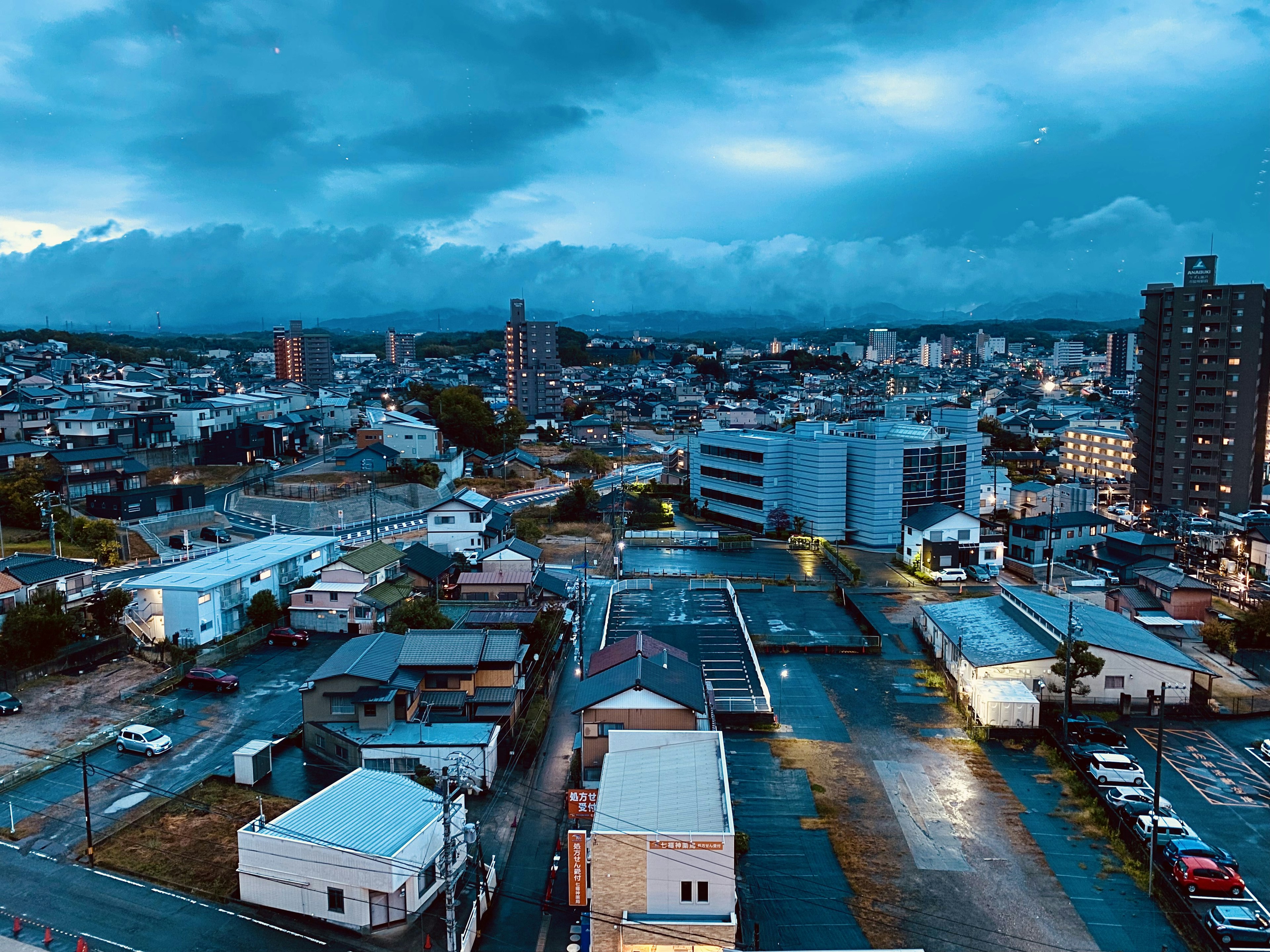 Urban landscape with blue skies and clouds featuring residential and commercial buildings