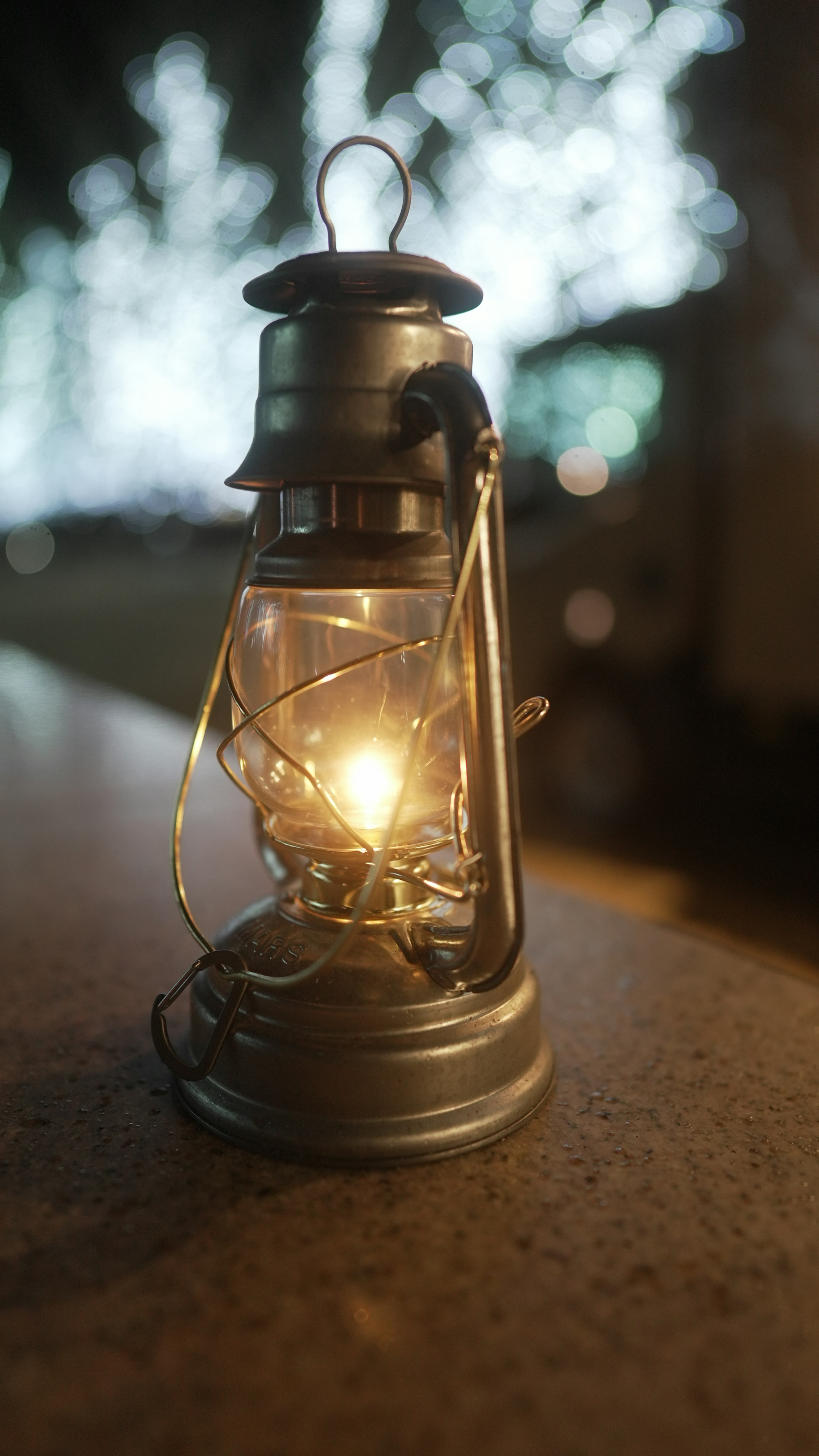 A classic lantern emitting a warm light placed on a table