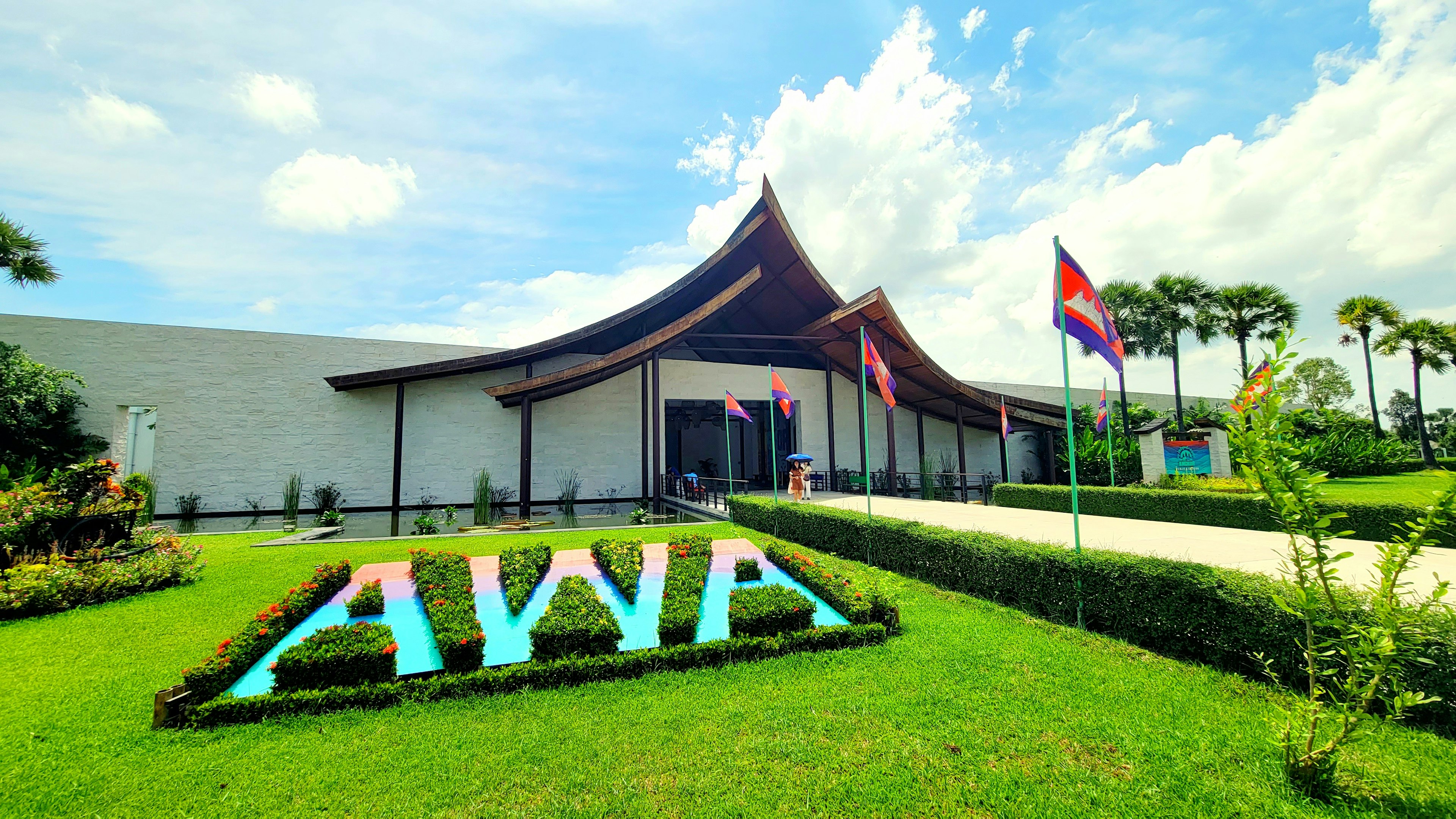 AWA building surrounded by a beautiful garden blue sky and white clouds