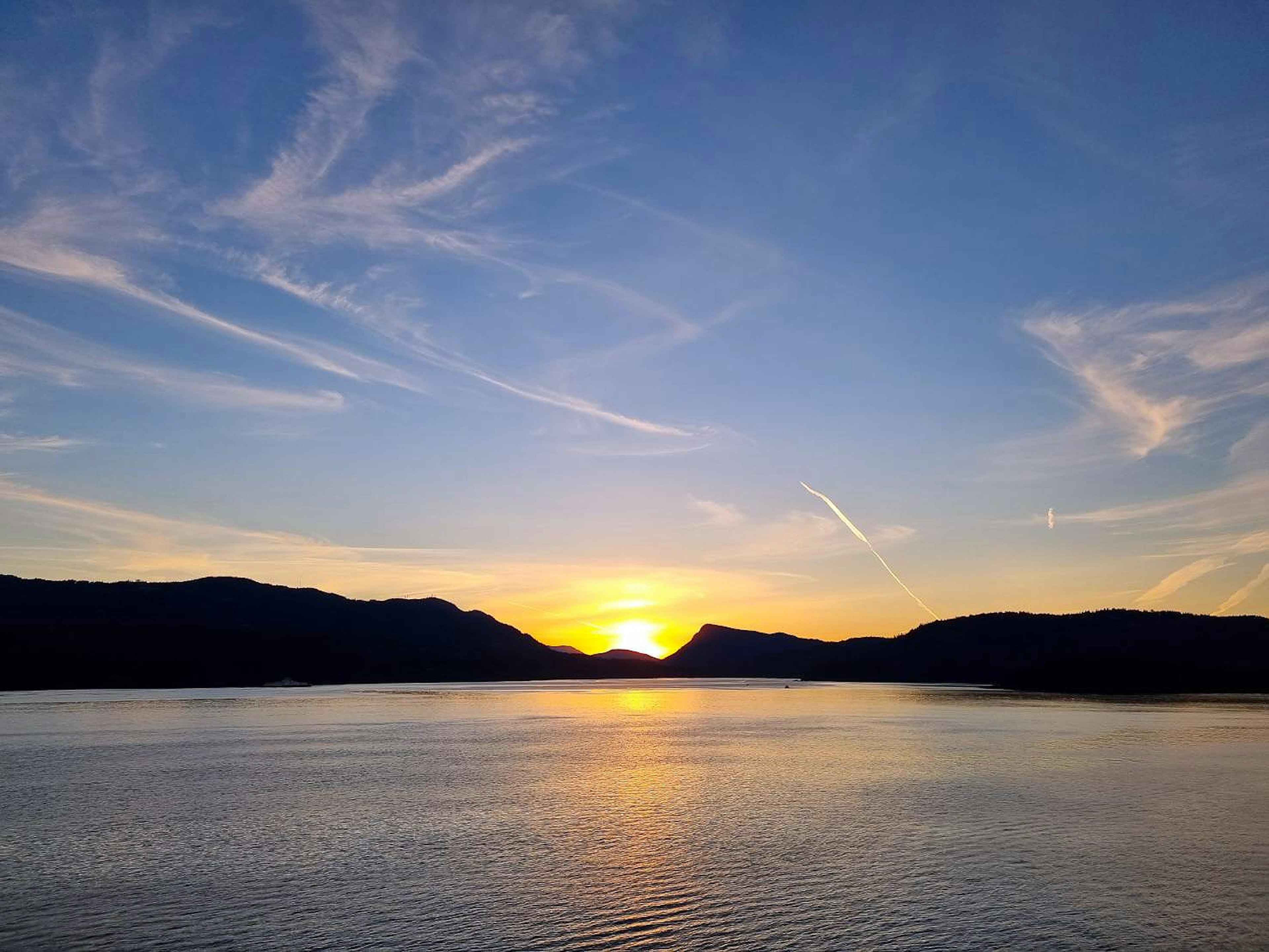 Hermoso atardecer sobre un lago con montañas al fondo