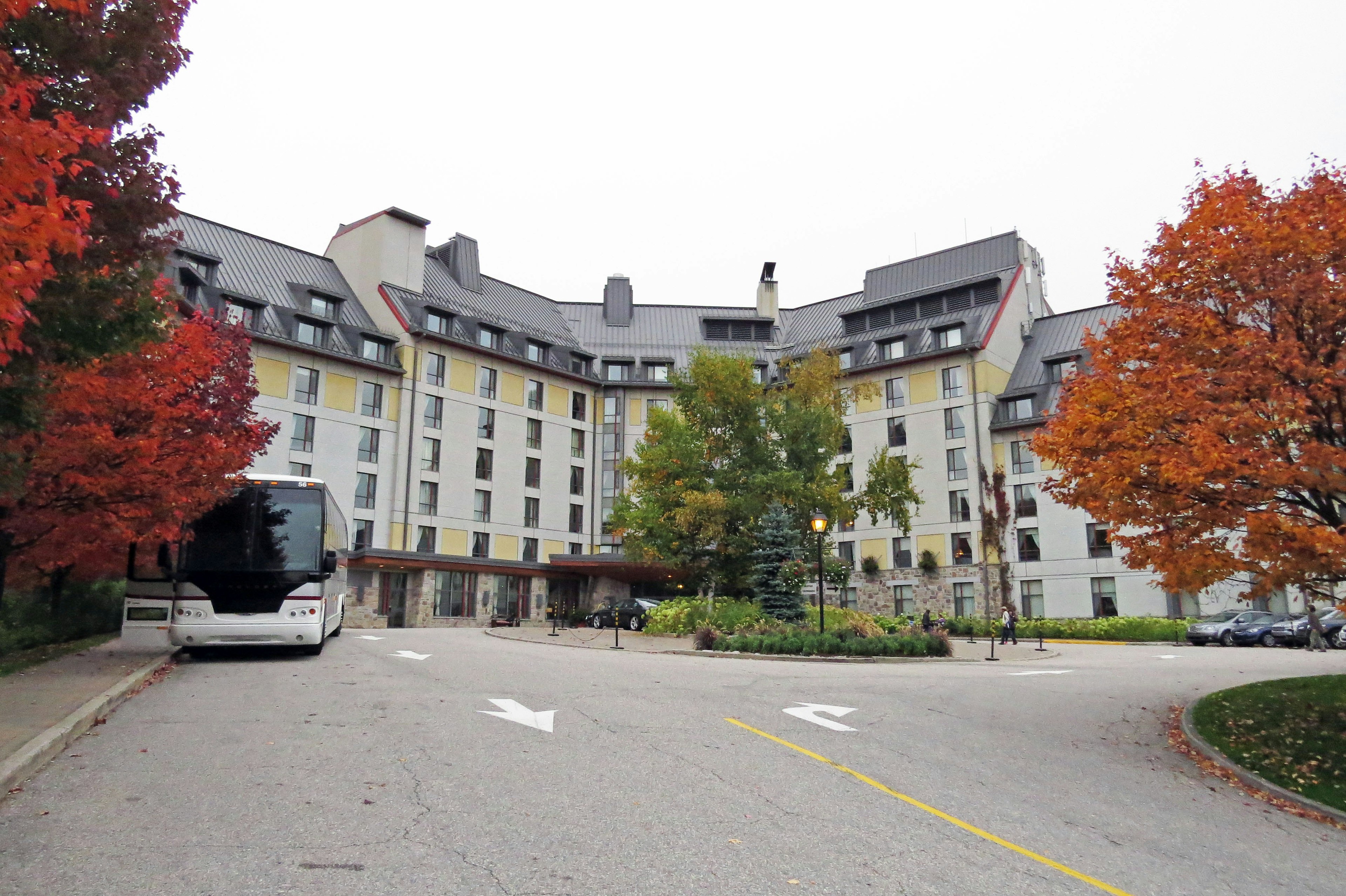 Exterior view of a lodging facility surrounded by autumn foliage and a bus