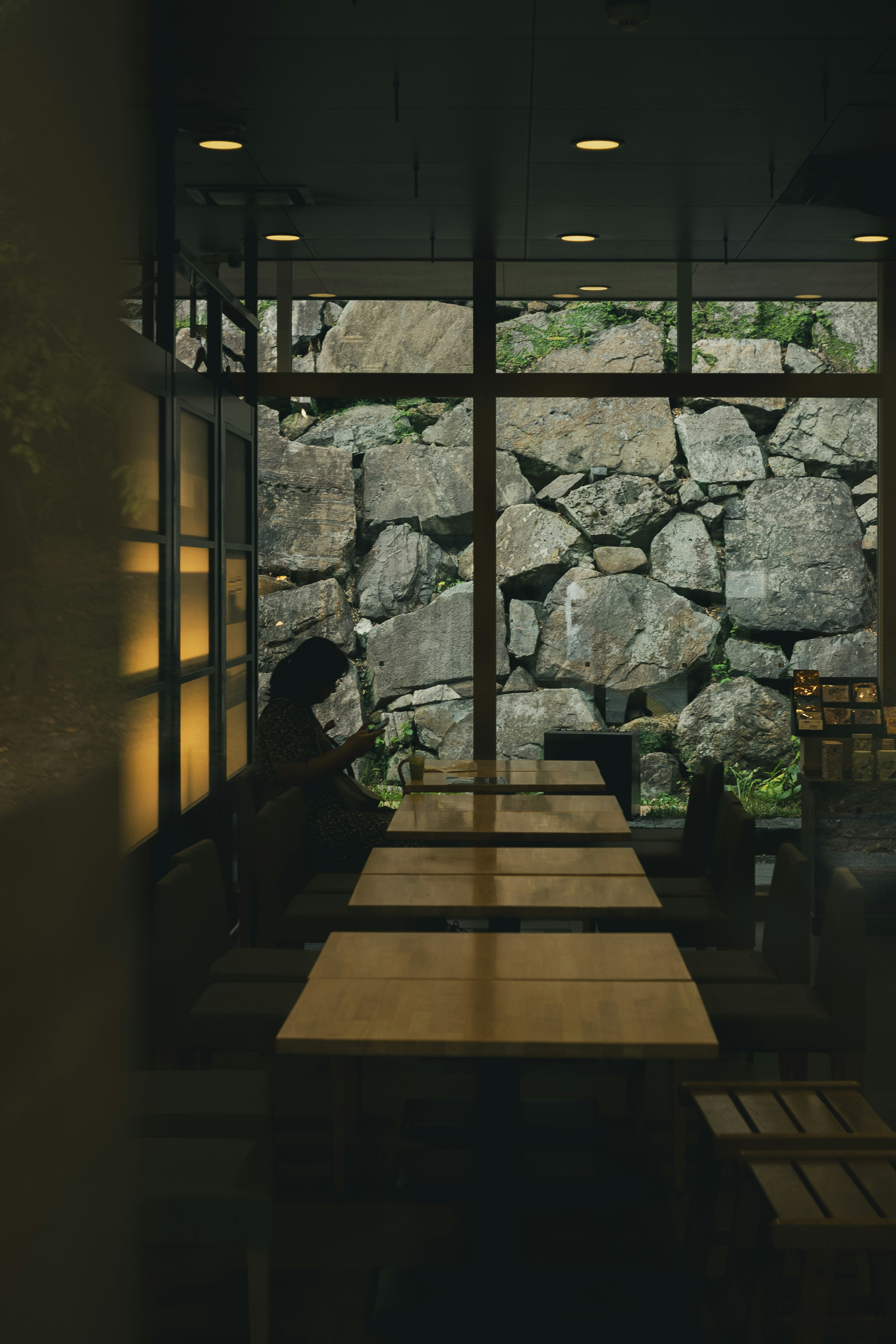 Quiet café interior with tables and a stone wall visible