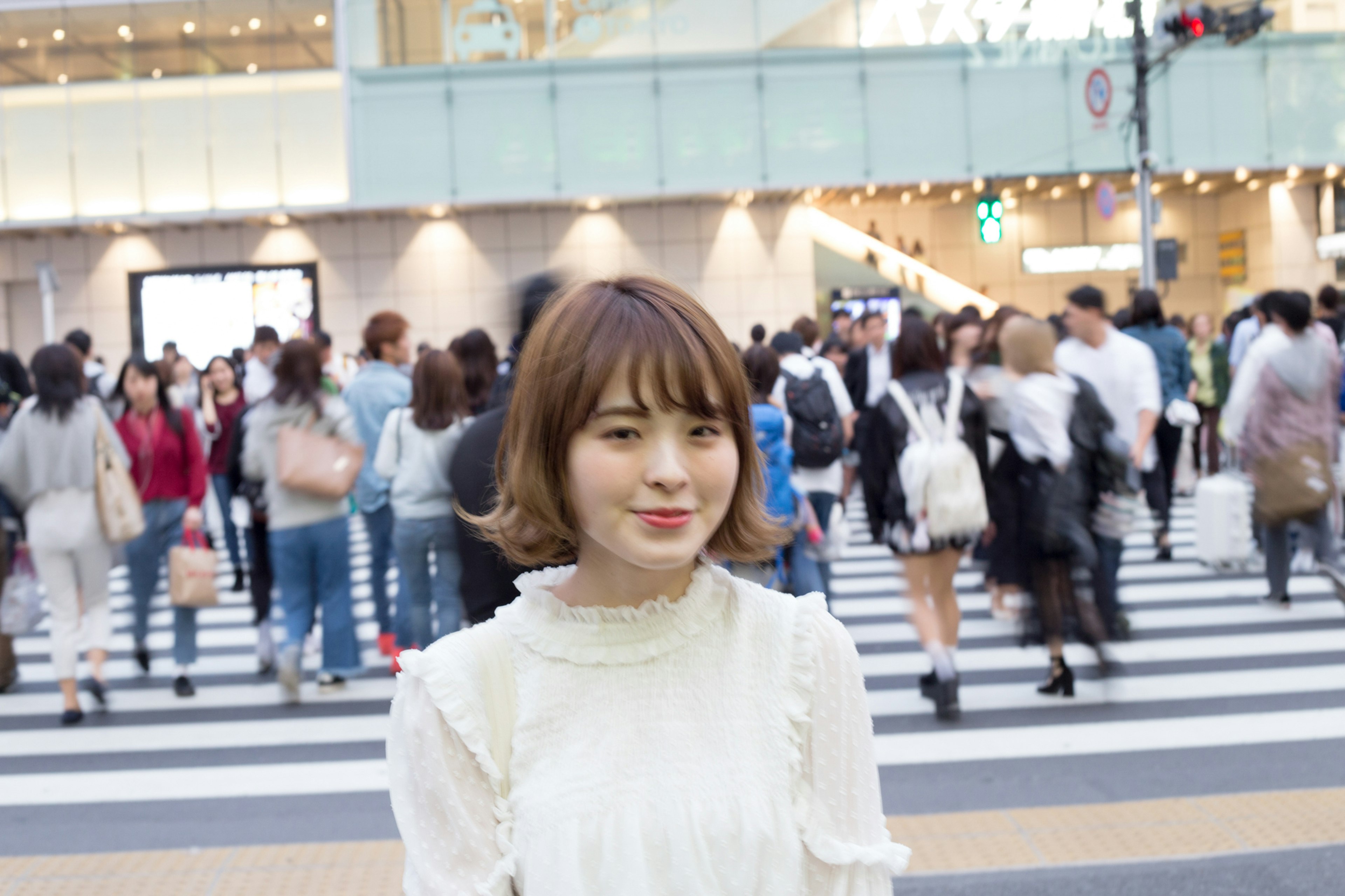 Young woman smiling in the foreground with a crowd in the background