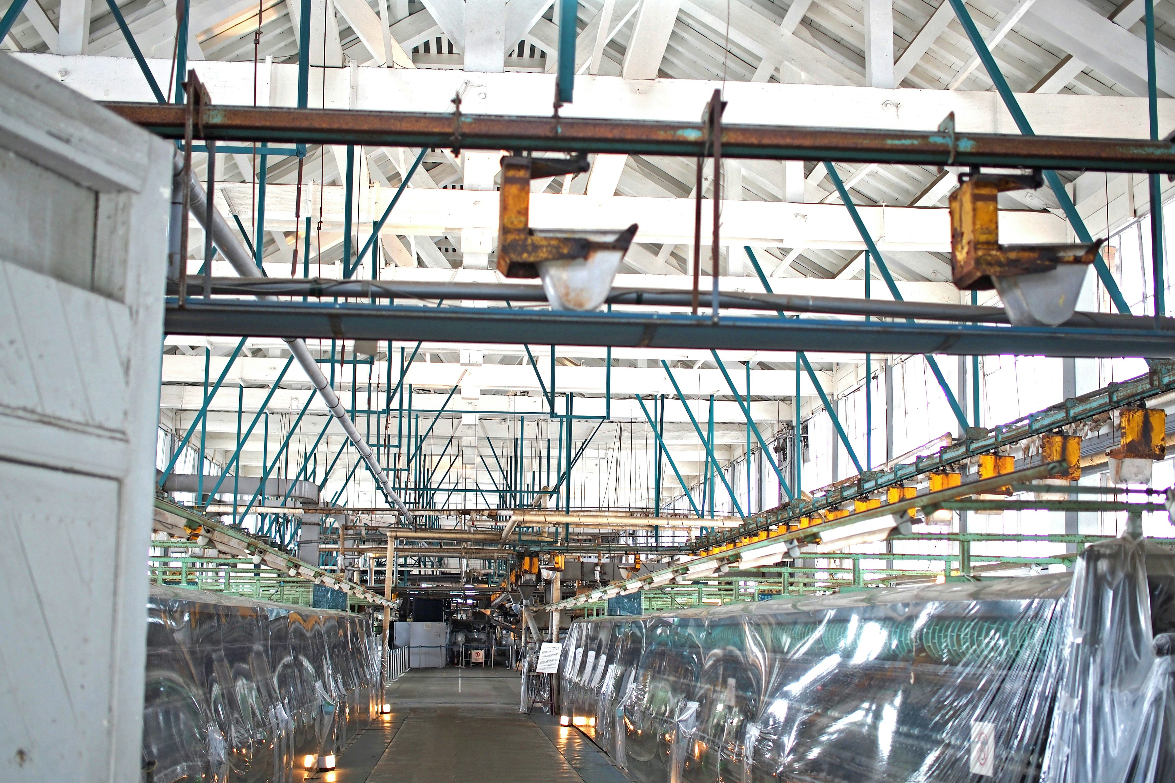 Intérieur spacieux d'une usine avec structure de plafond et éclairage visibles