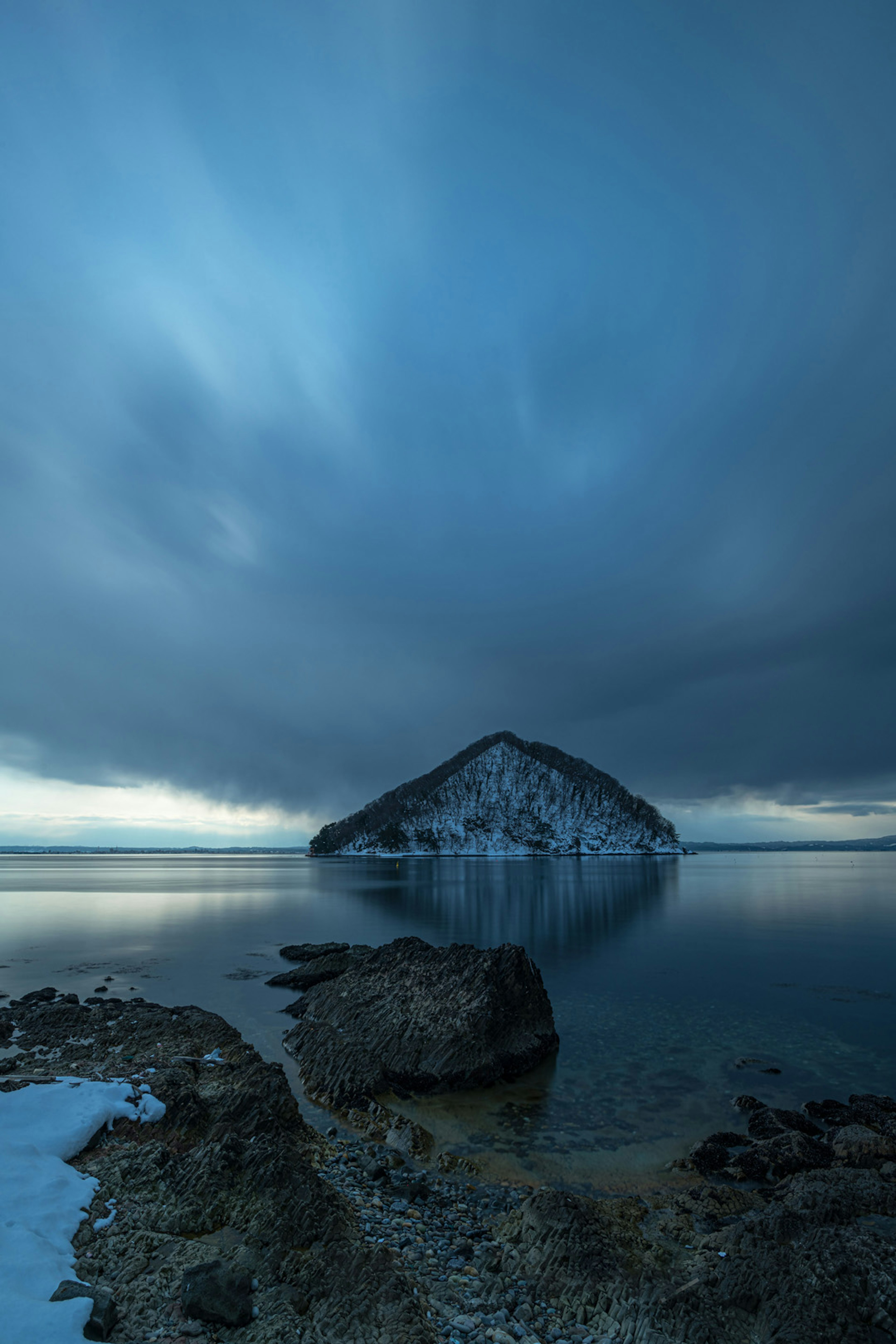 Paesaggio di un'isola innevata e di un mare blu