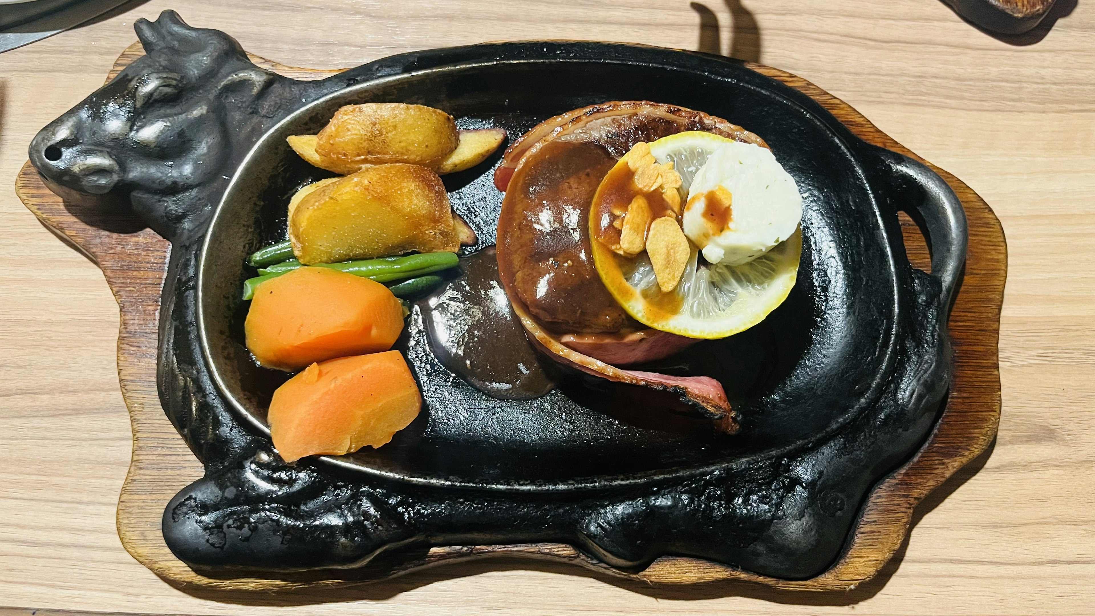 Sizzling plate with hamburger steak and assorted vegetables