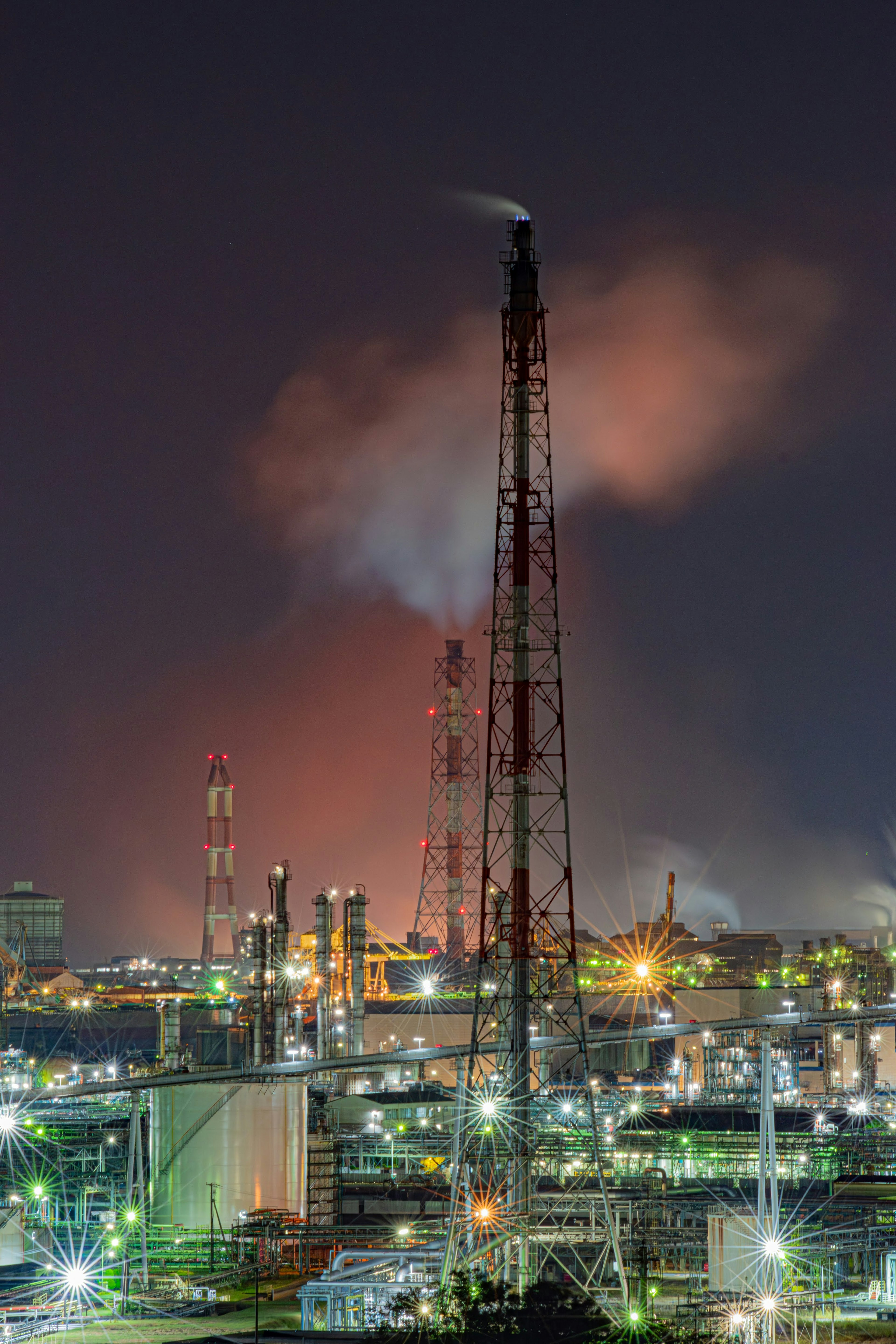 Night view of an industrial area with smokestacks and lights