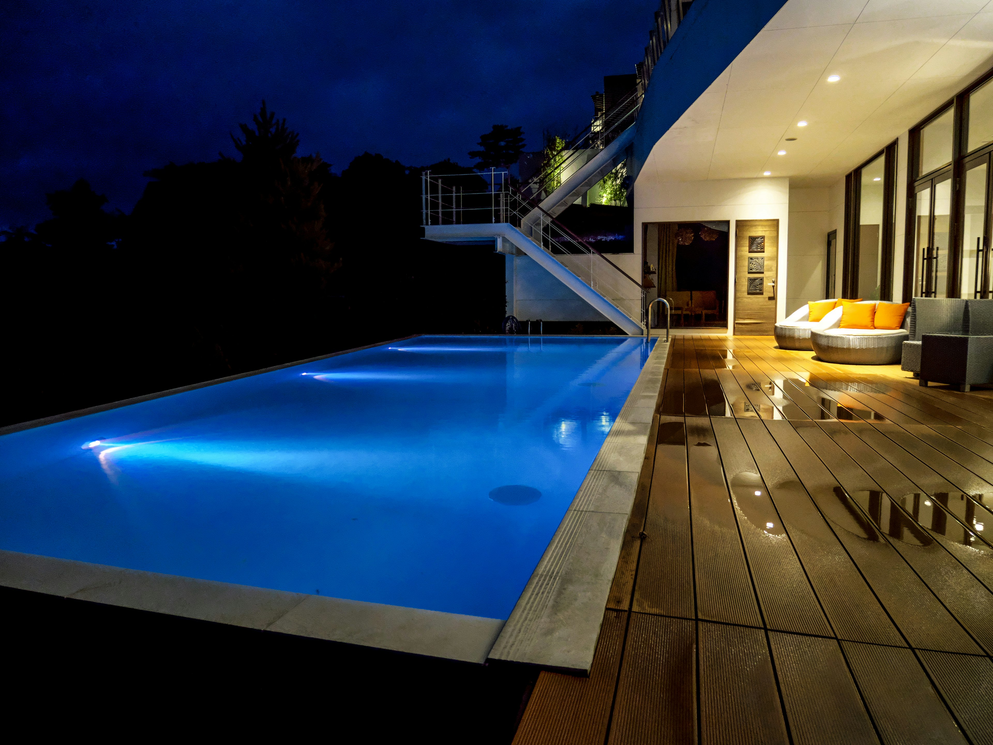 Vue nocturne d'une maison moderne avec piscine