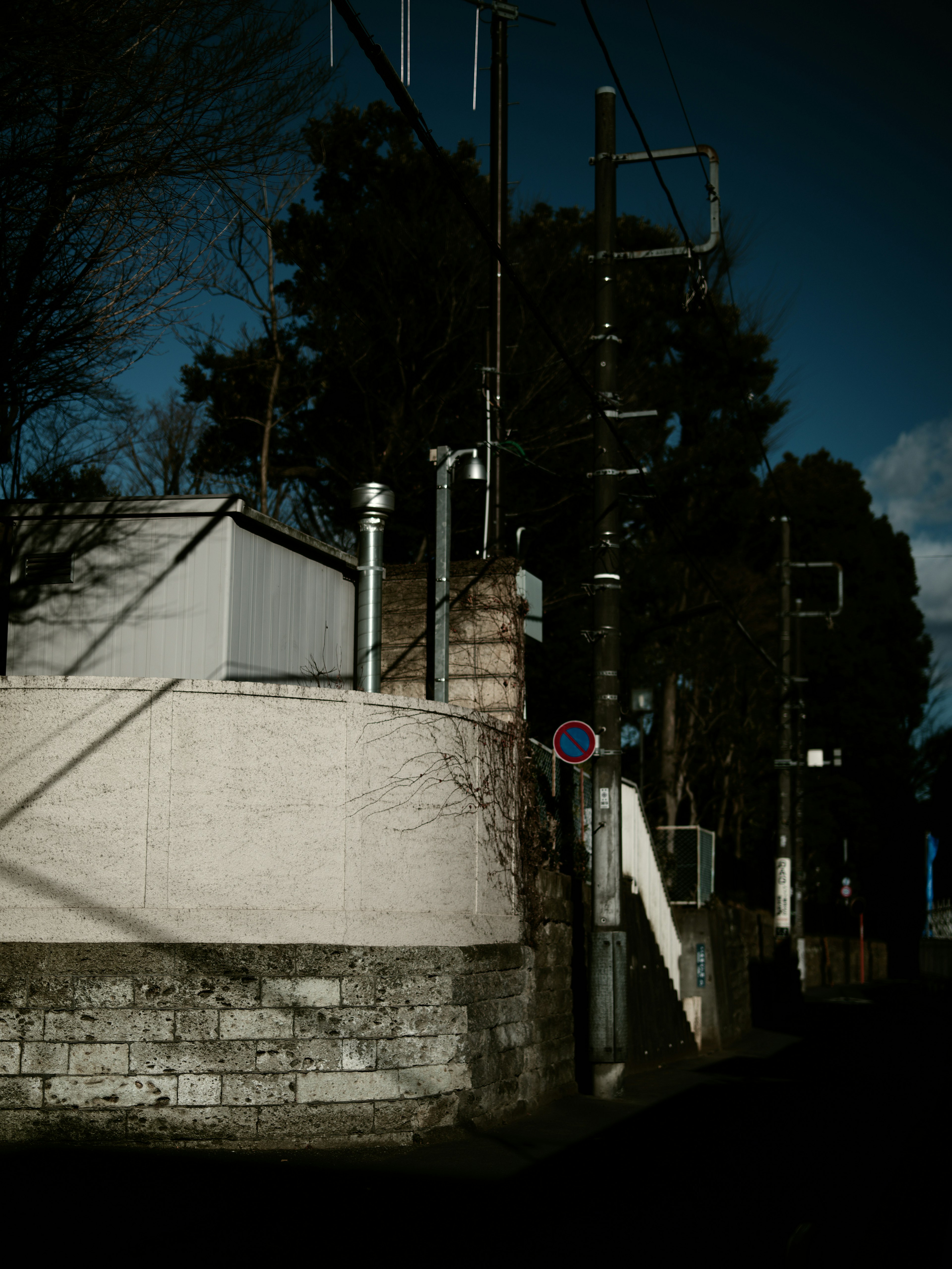 Urban scene with a dark background featuring lighting fixtures and a traffic sign