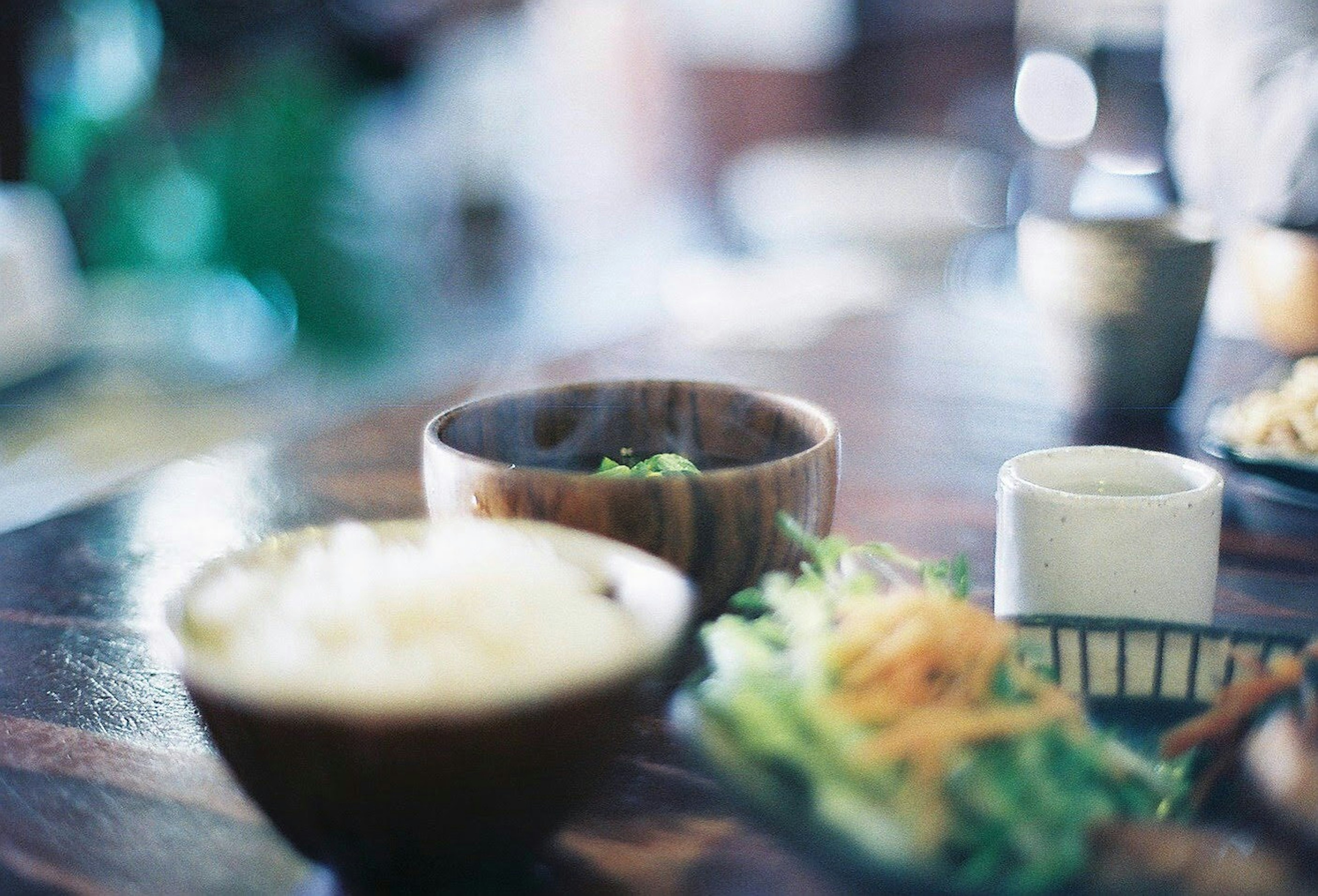 A beautiful dining scene featuring dishes in wooden bowls and rice on a table