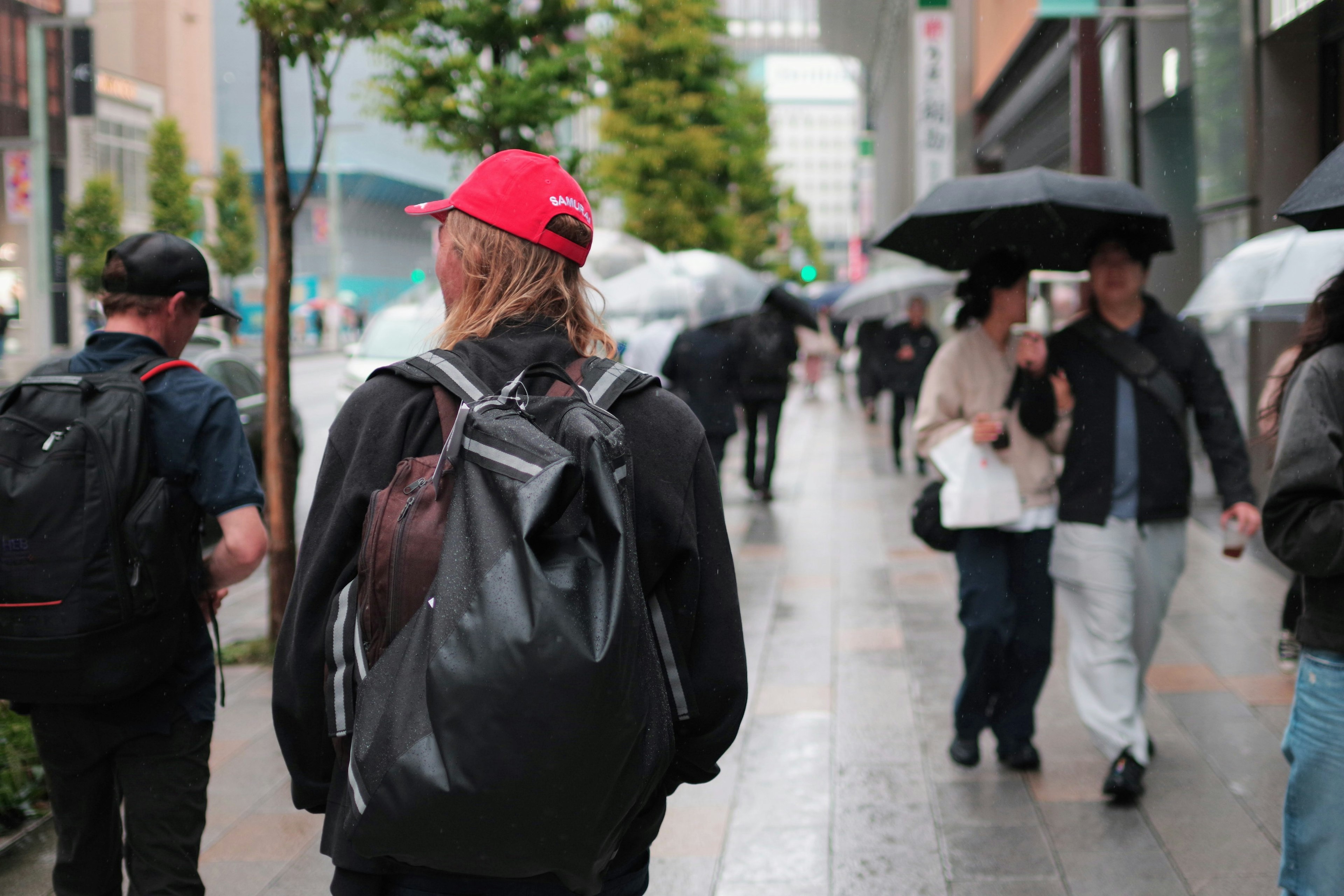 在雨中走在街上的人们，手持雨伞