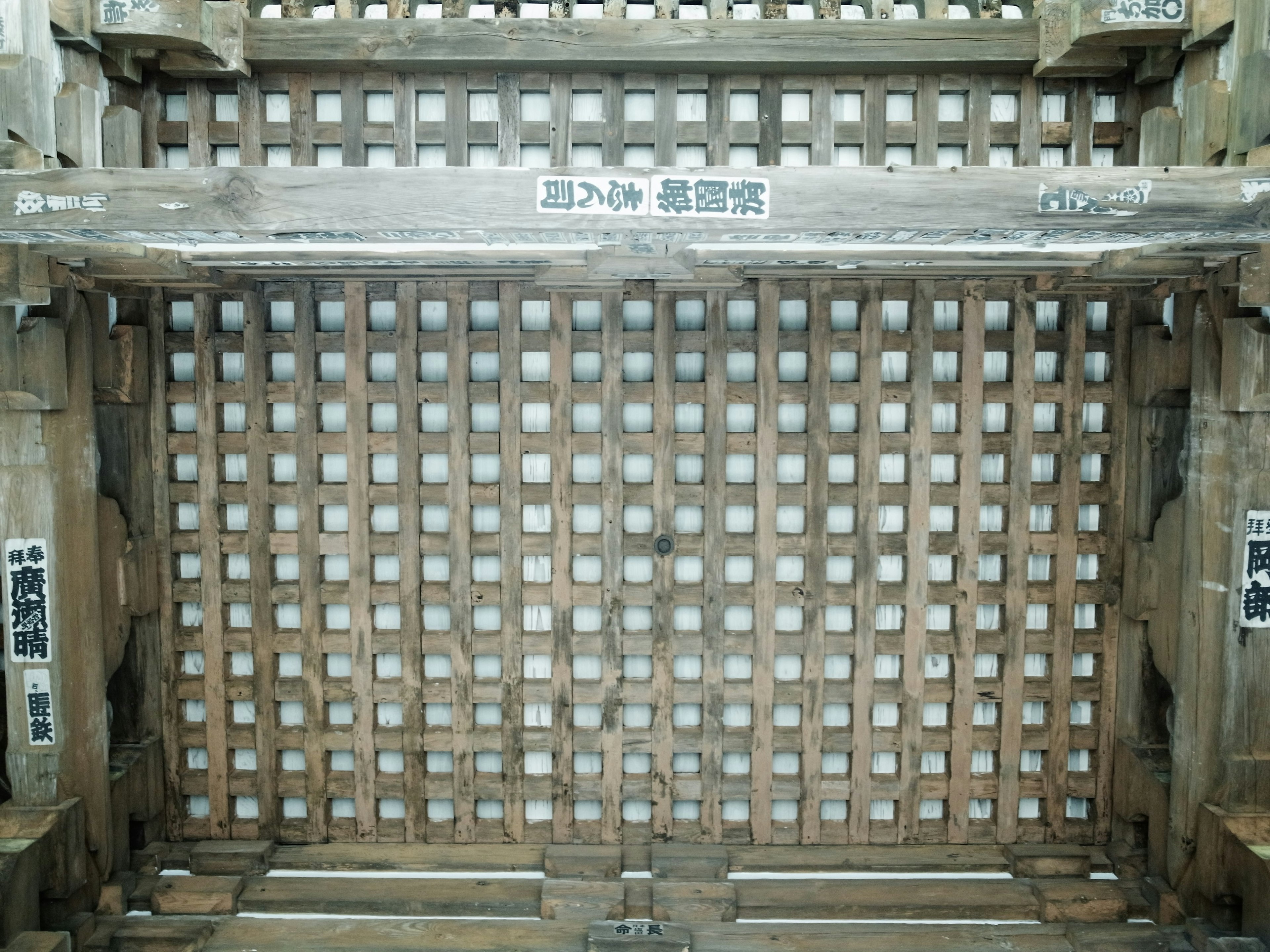 Wooden lattice wall with Japanese signage attached