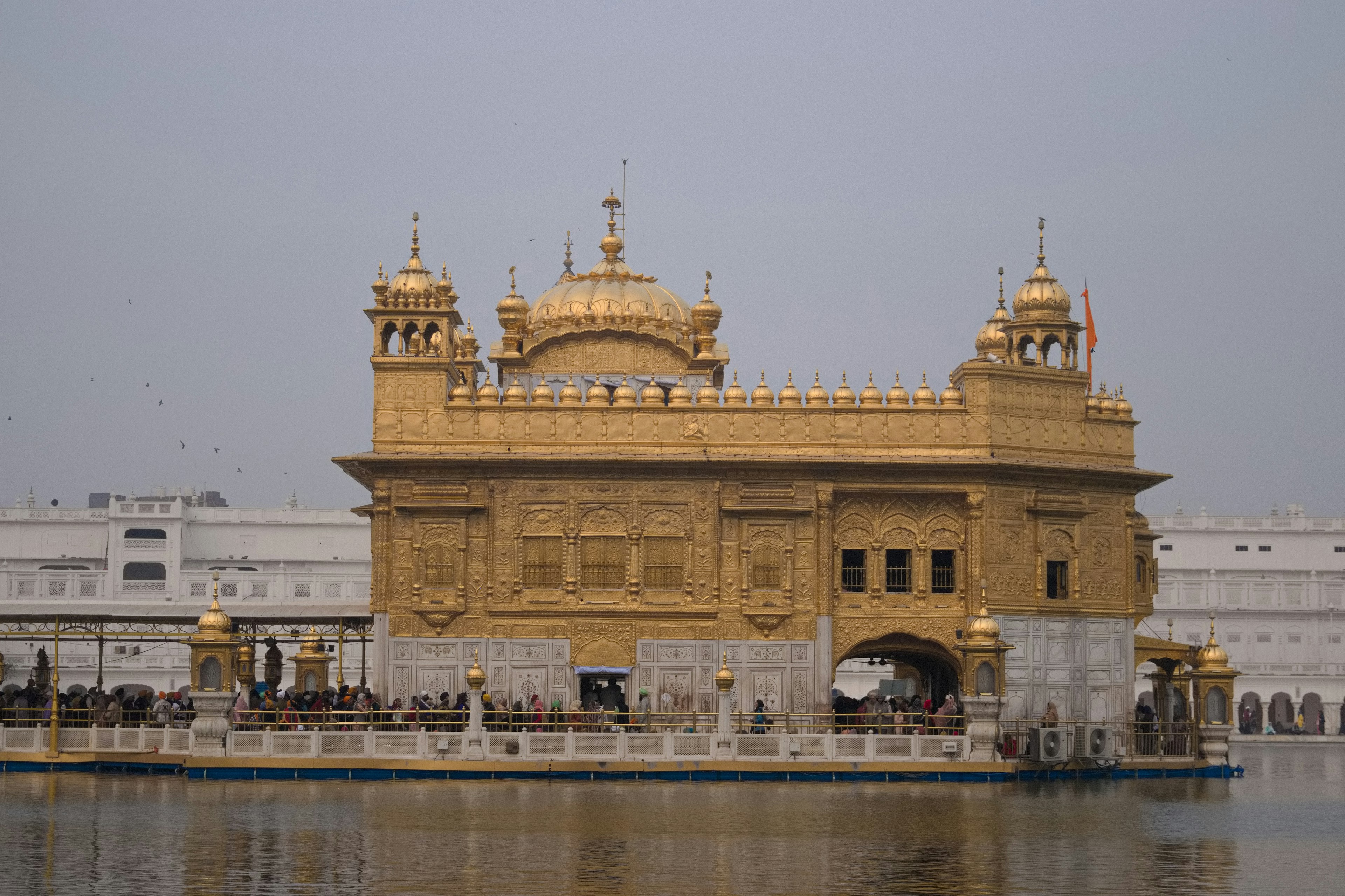 Golden temple reflecting on calm water in serene landscape