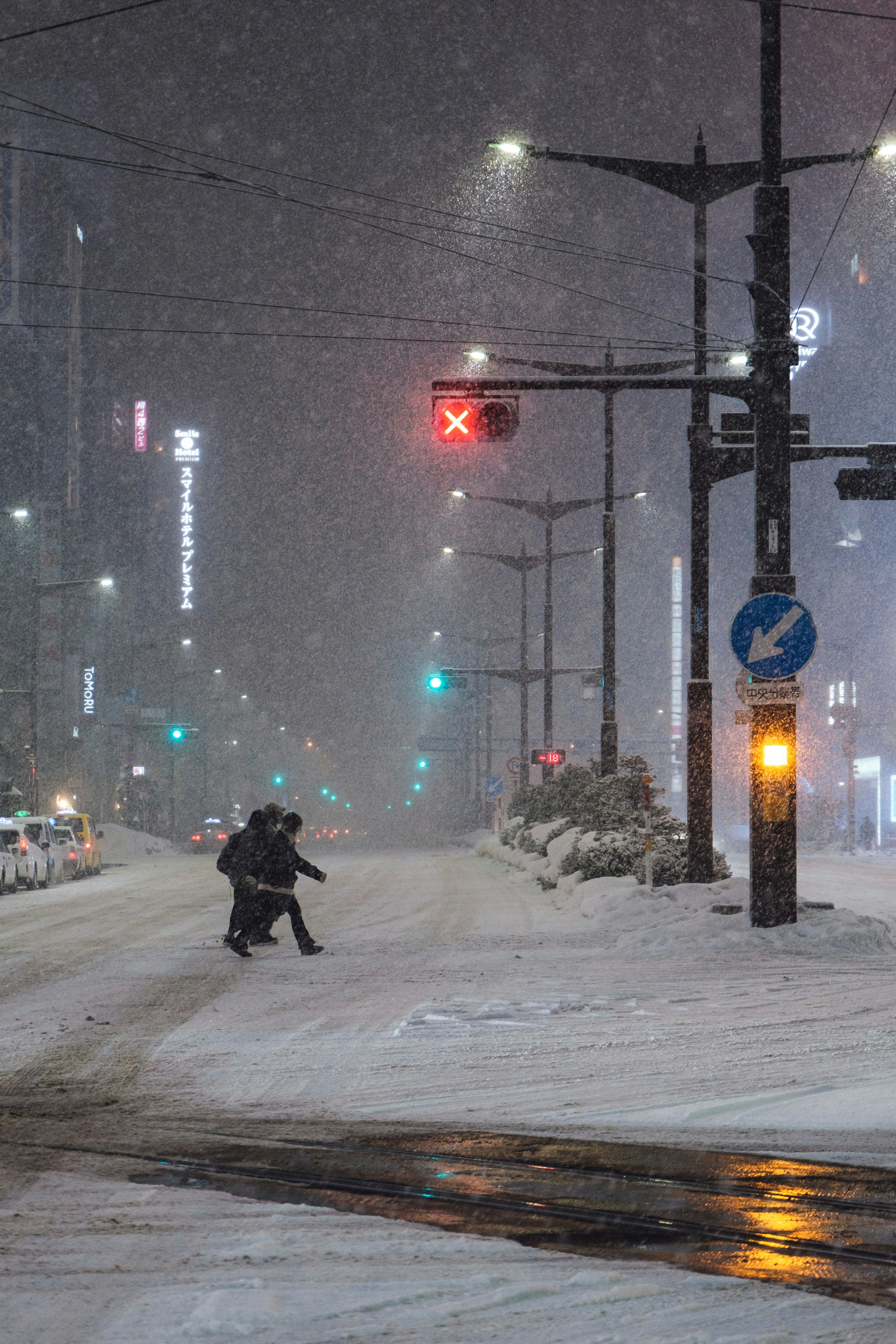 Eine Person, die an einer Ampel während einer verschneiten Nacht in der Stadt wartet