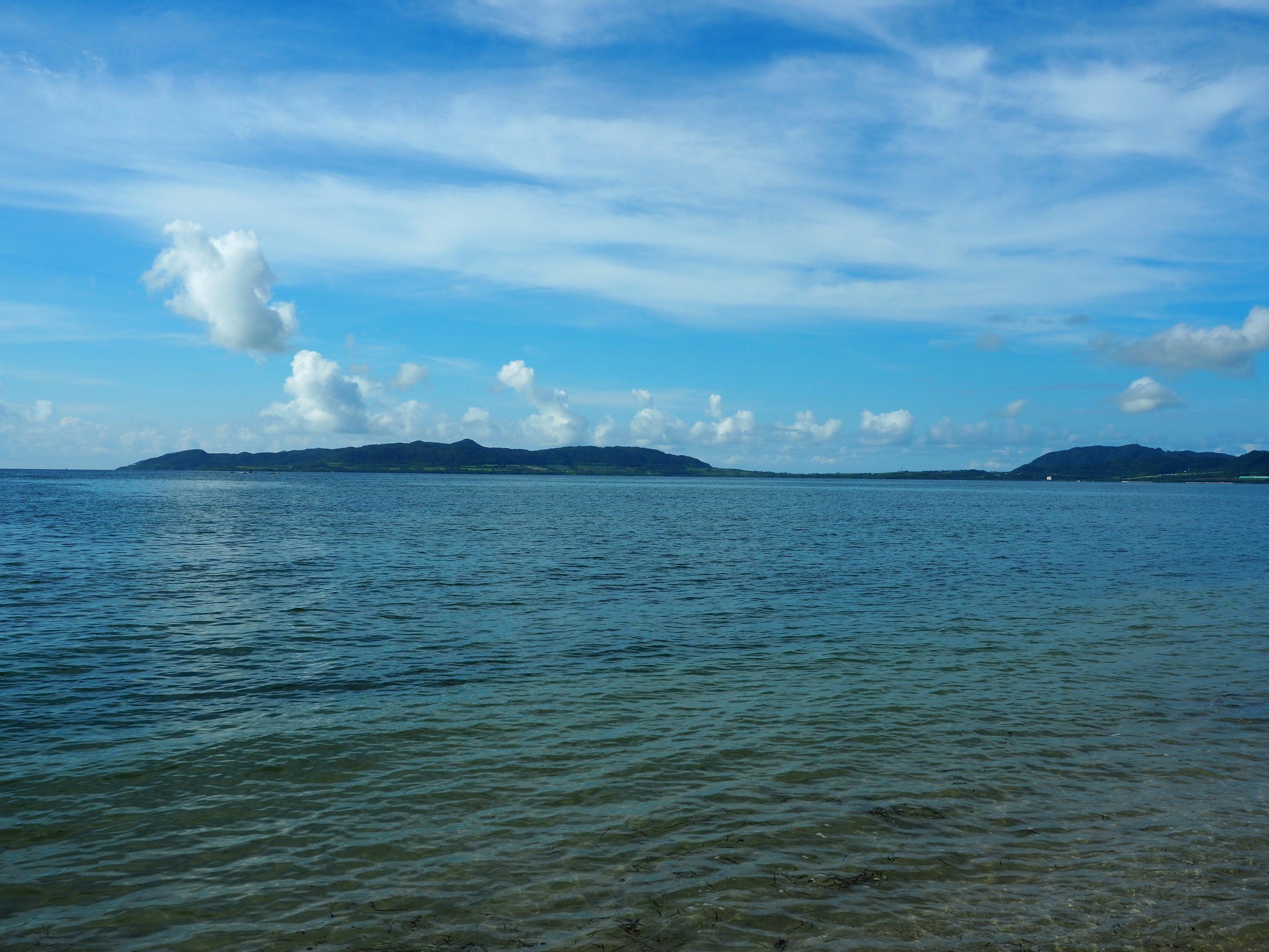 Pemandangan laut biru dan langit dengan pulau-pulau di kejauhan