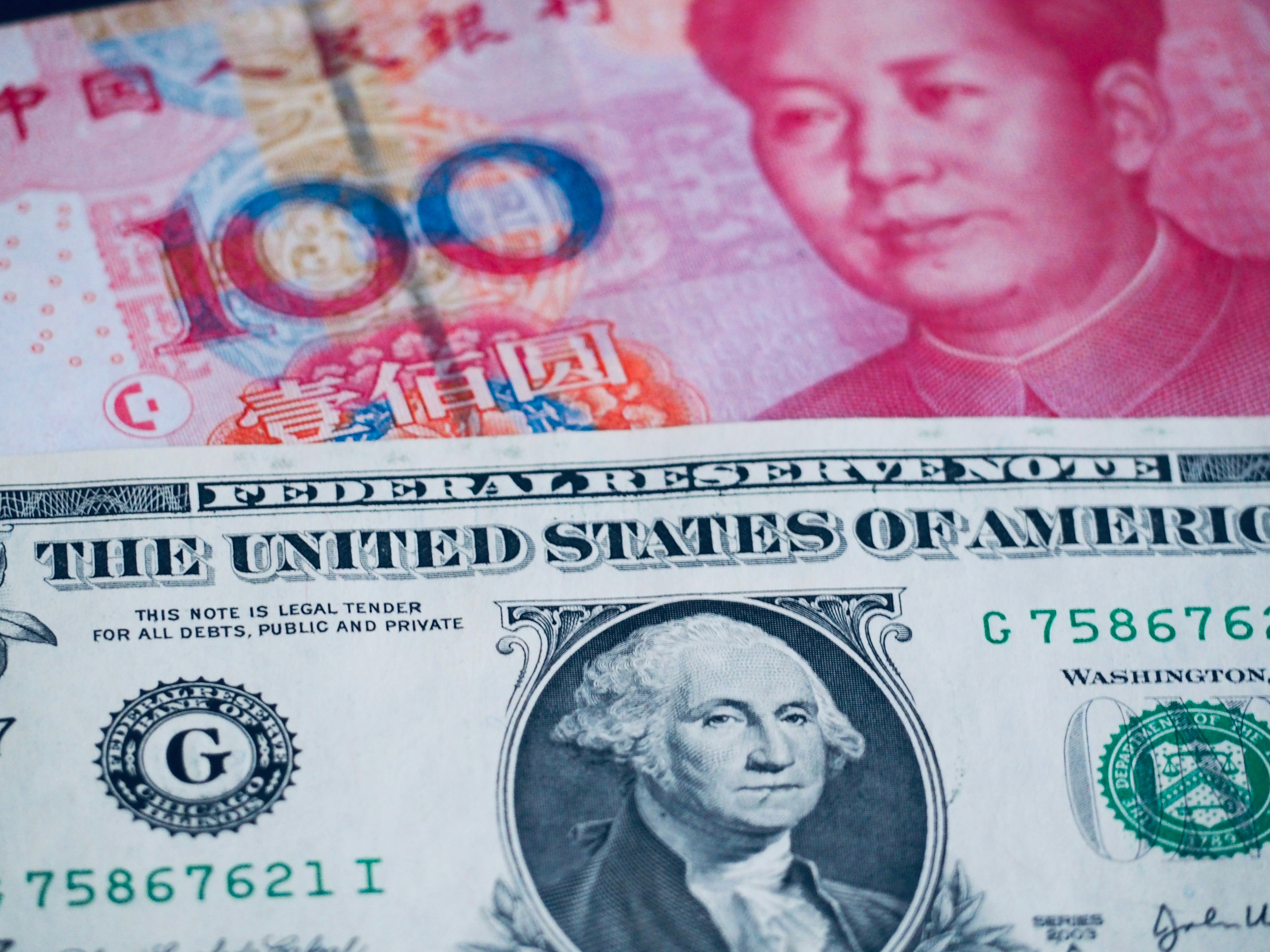 Image of a Chinese Yuan and an American Dollar bill side by side