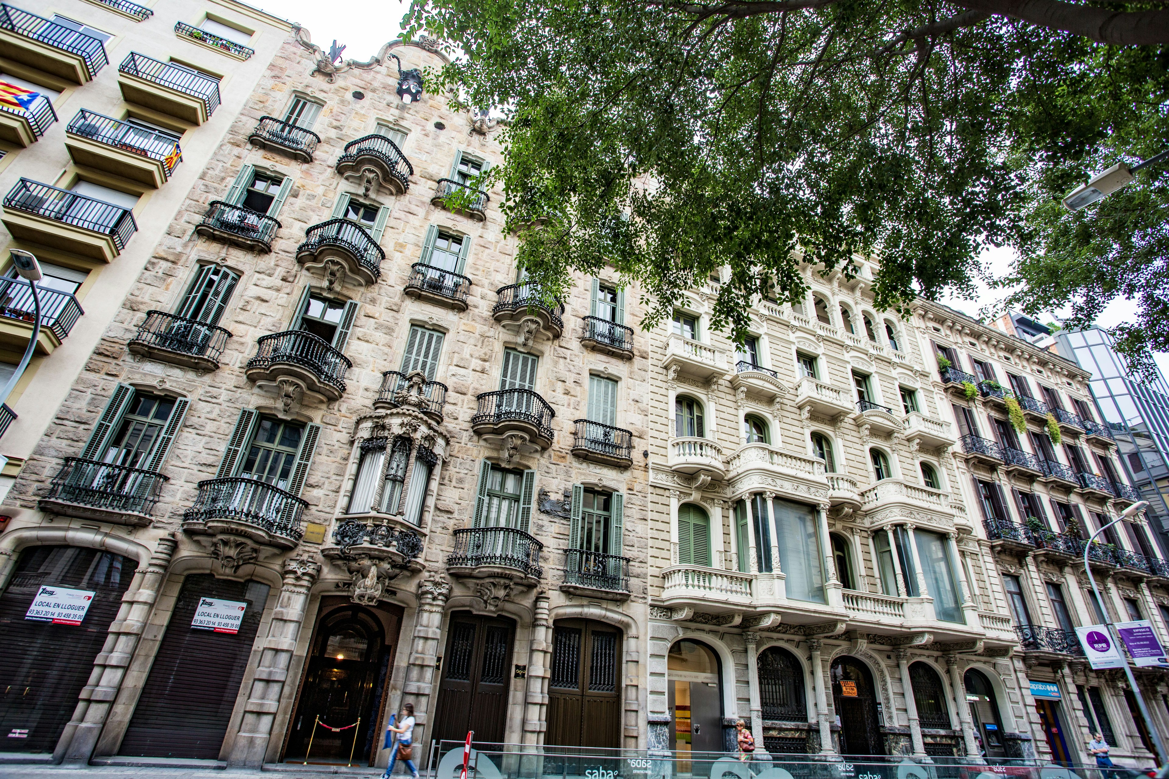 Historic building facade in Barcelona featuring iron balconies and decorative elements