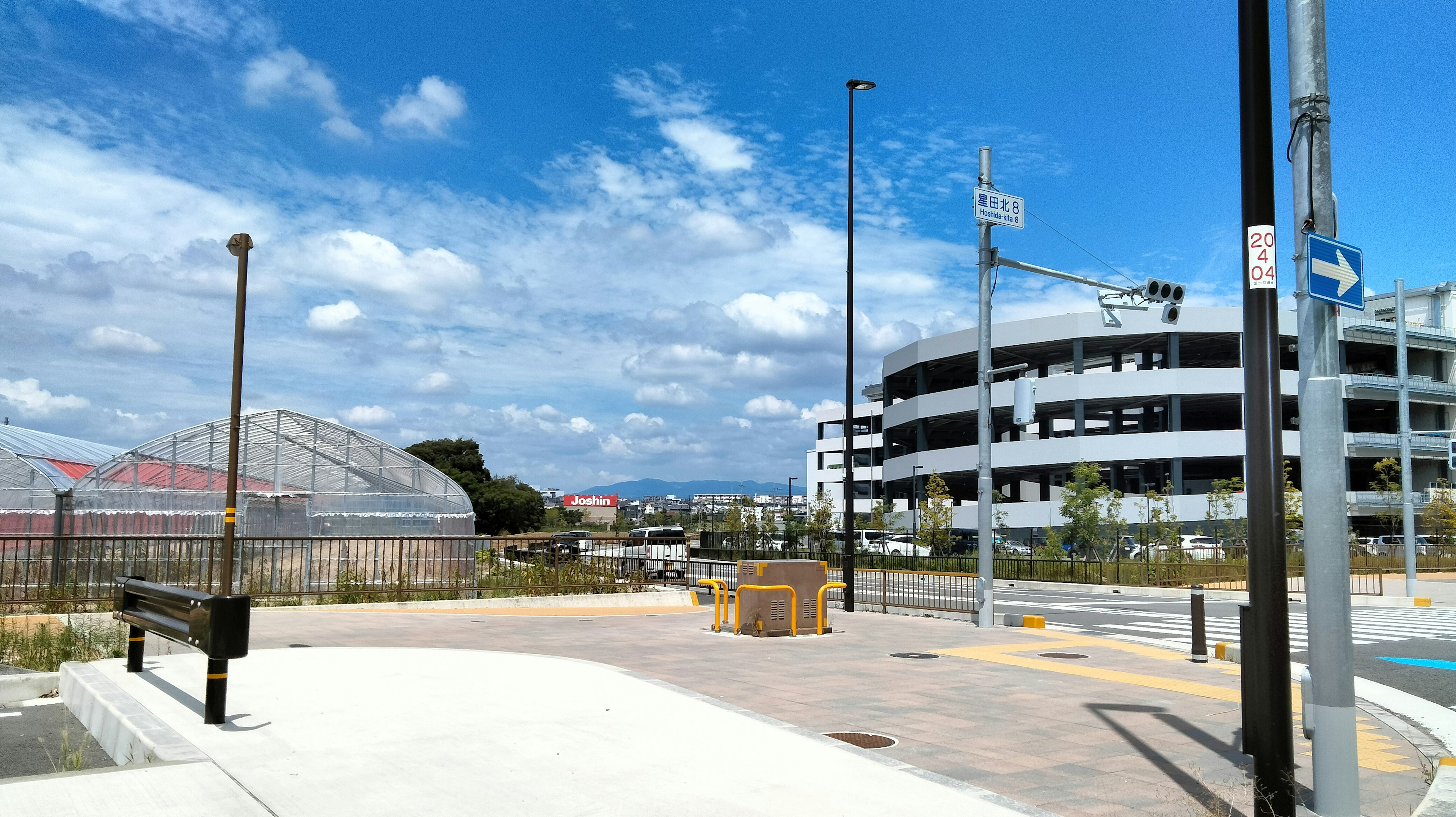 Parking lot under blue sky with surrounding scenery