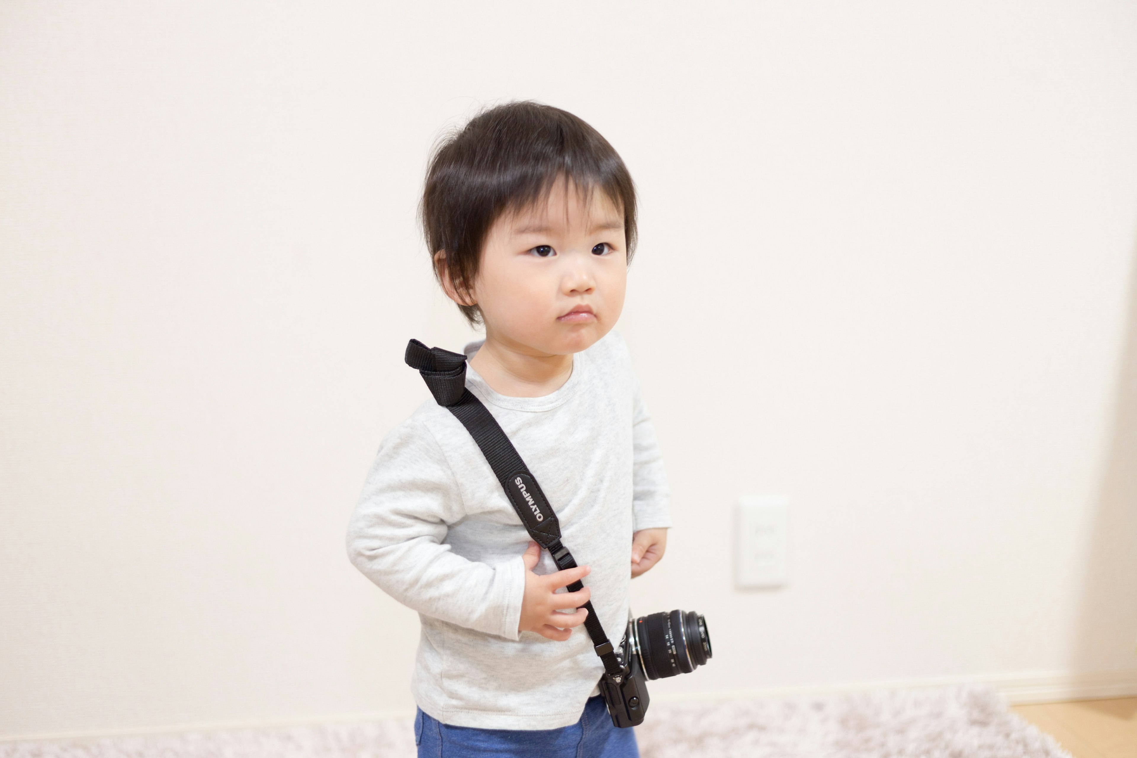 Young boy standing in a room with a camera