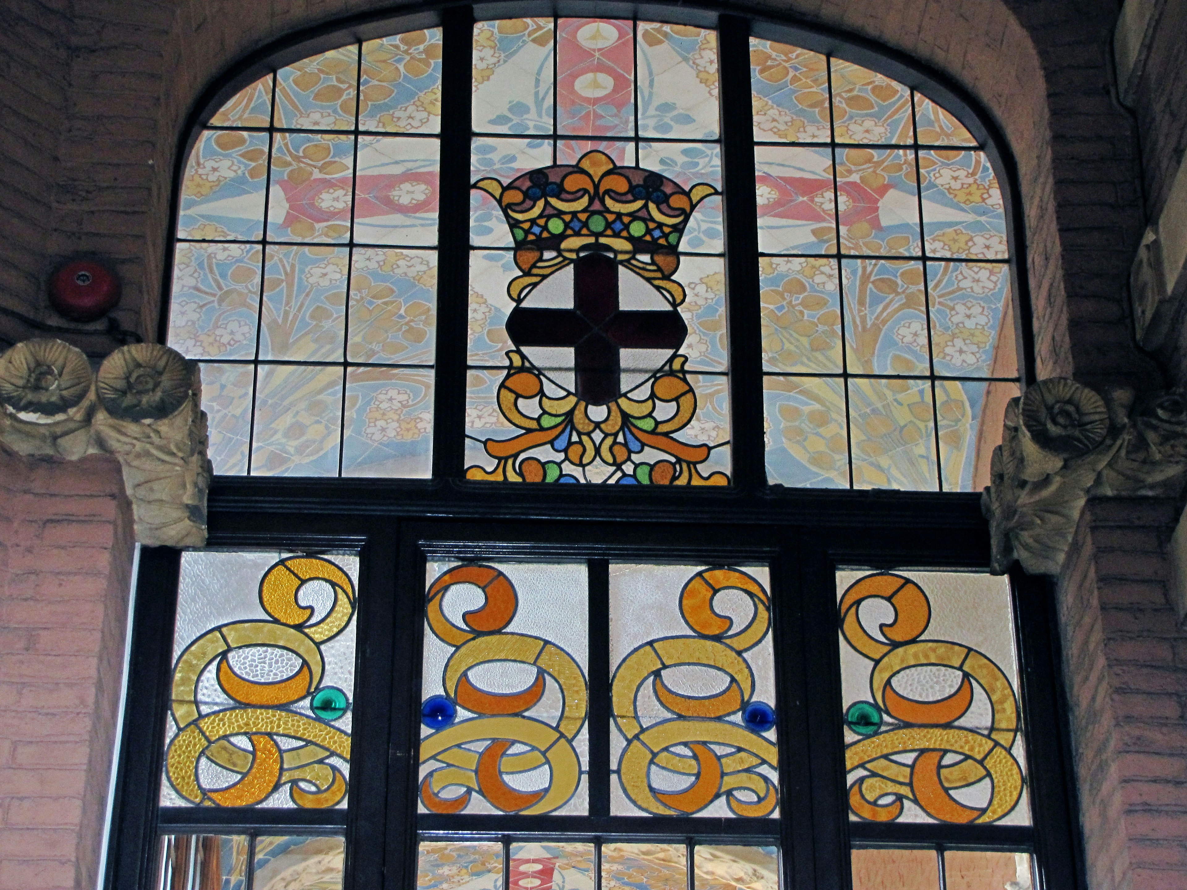 Hermosa ventana de vitrales con diseño de corona y cruz