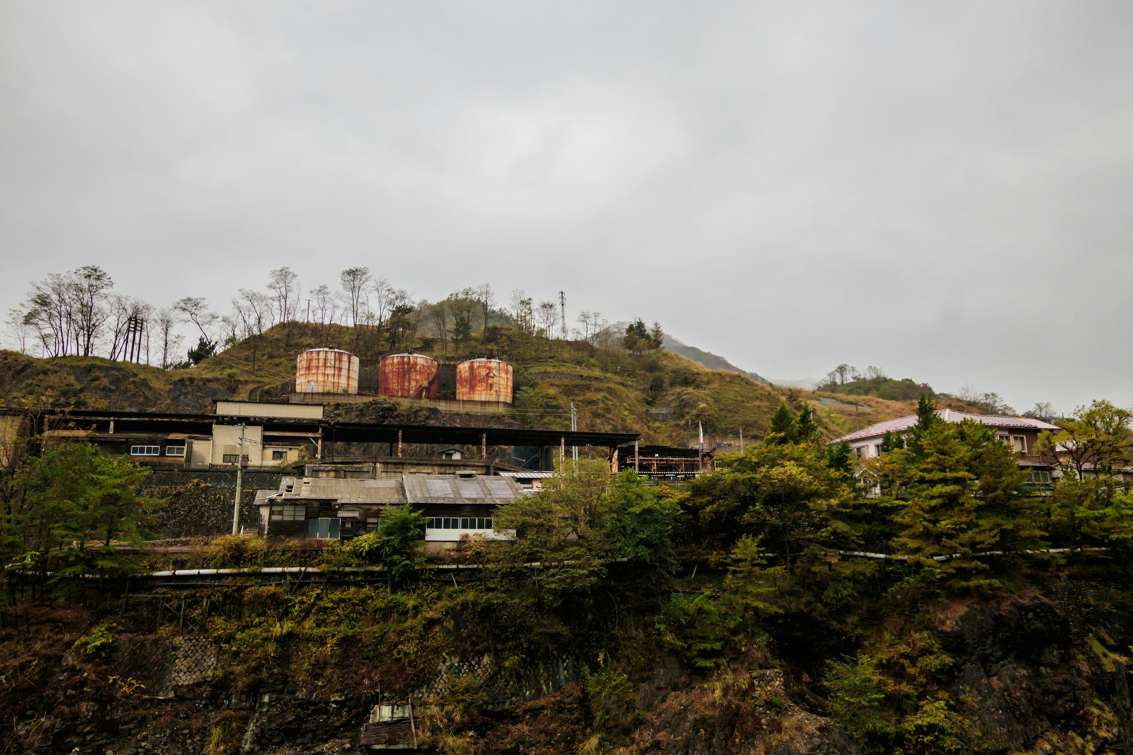 Paysage avec de vieux bâtiments et des réservoirs rouges sur une colline