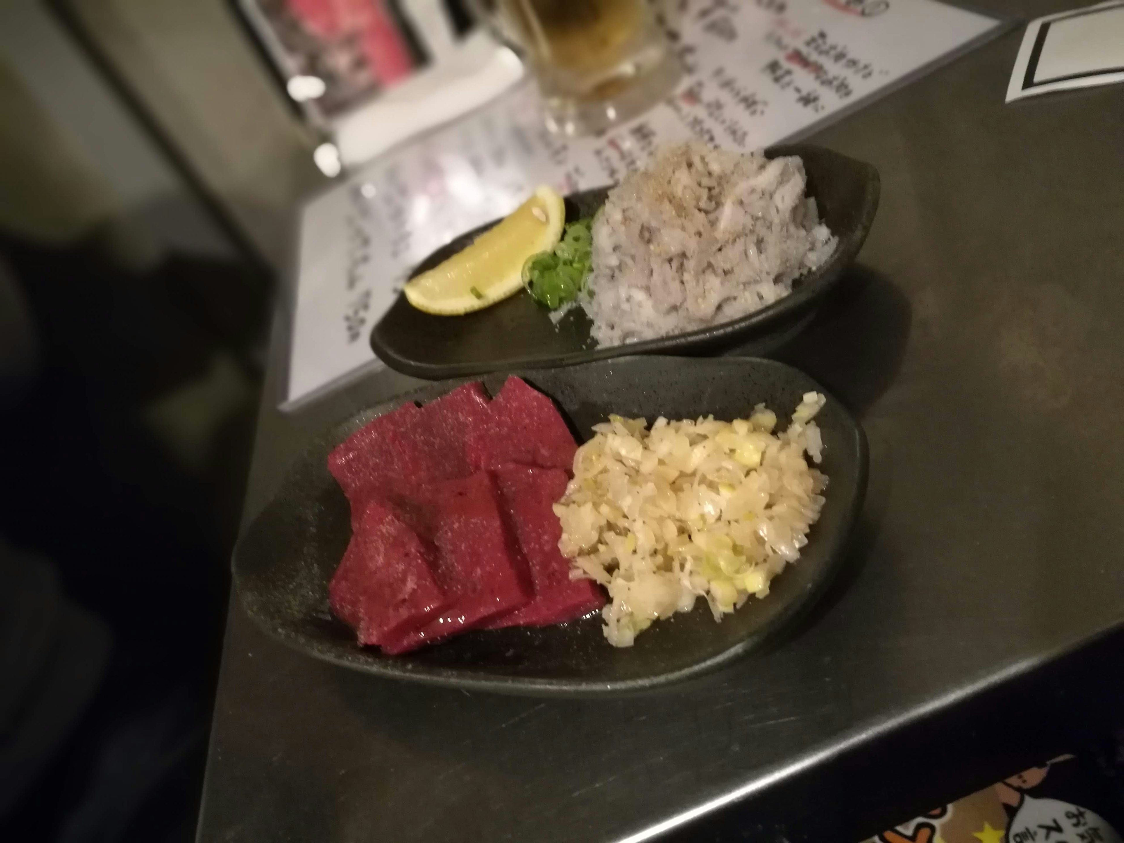 Platte mit rohem Fleisch und Garnelen-Sashimi mit Zitrone und Kräutern