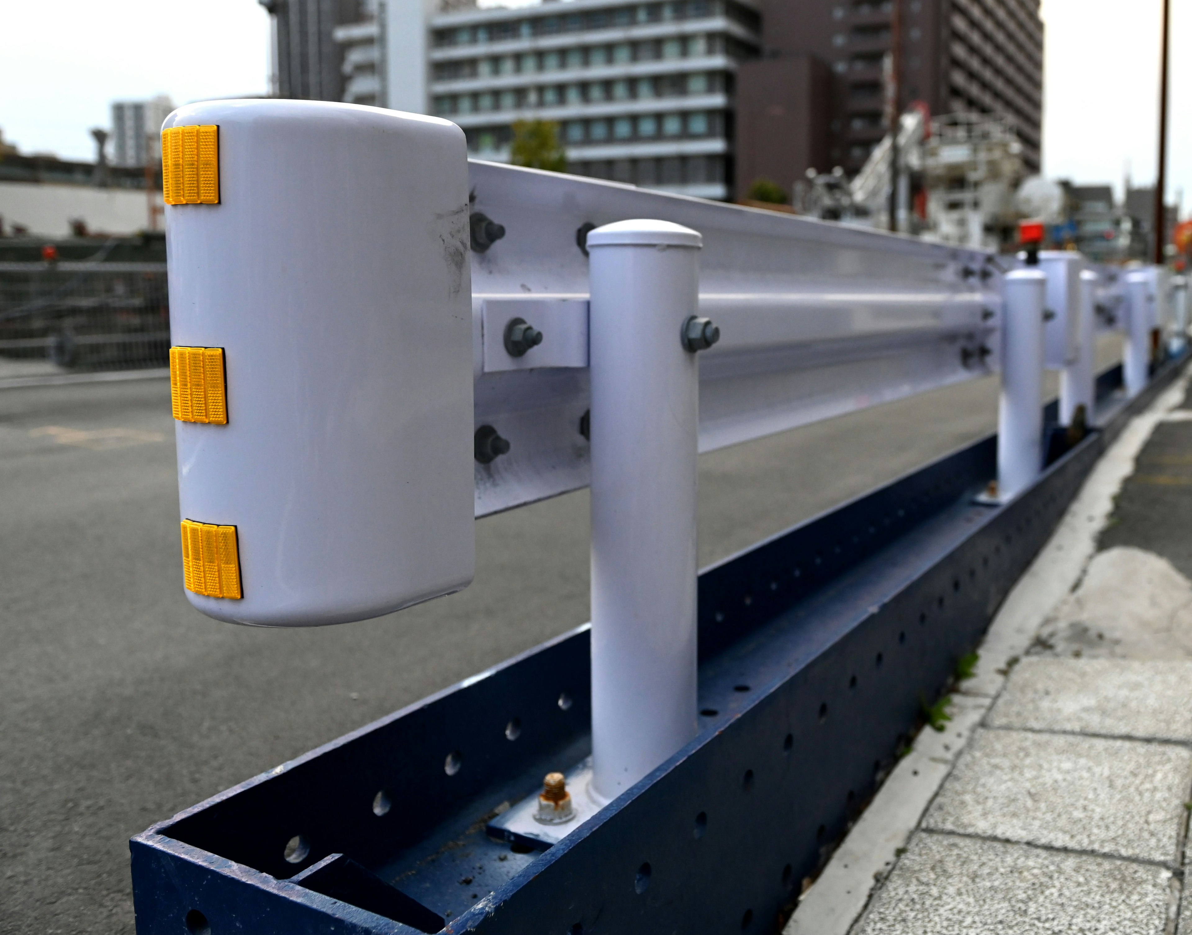 White and blue guardrail installed in an urban setting