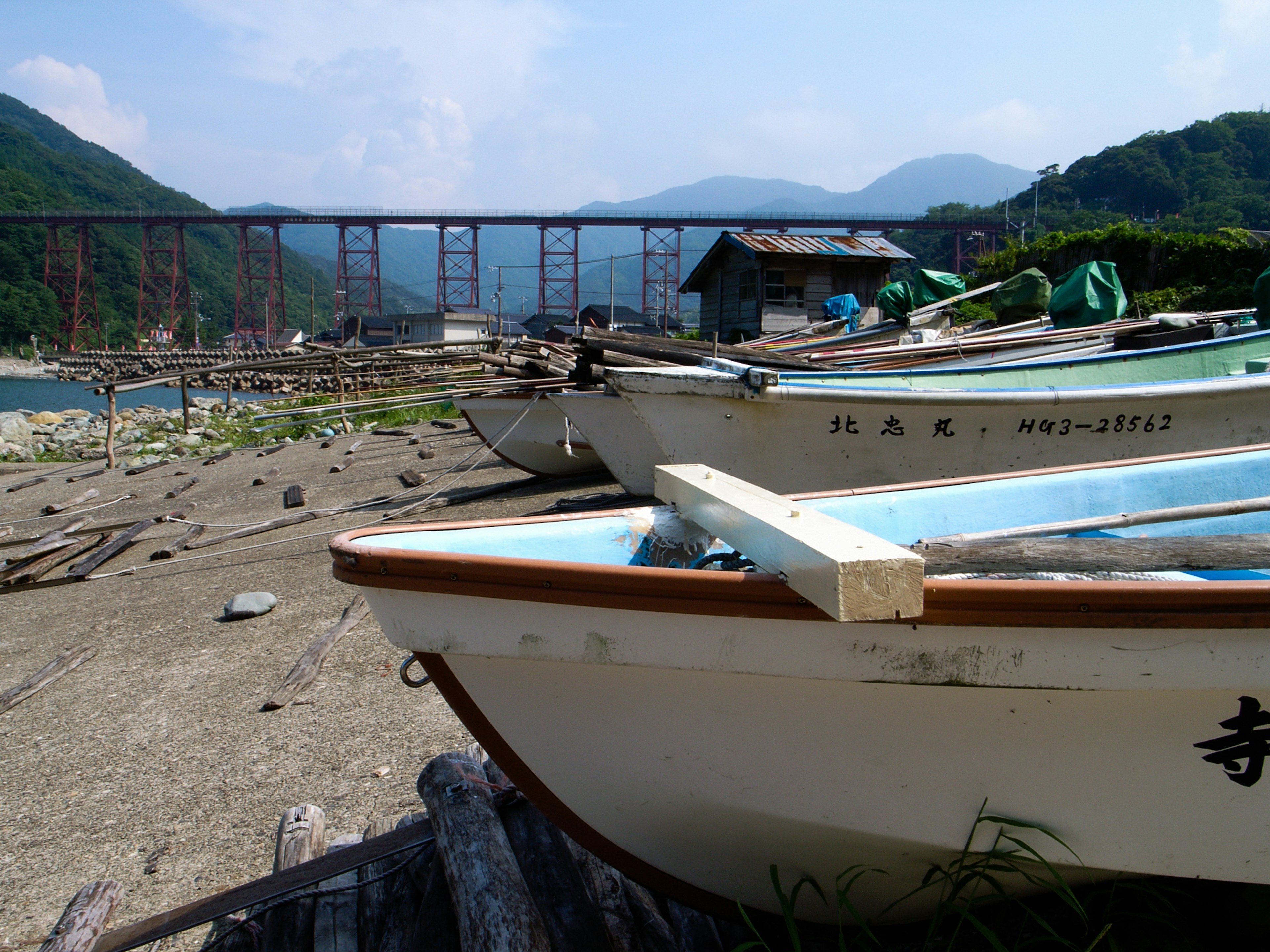 静かな河川と山々の背景に停泊している漁船群