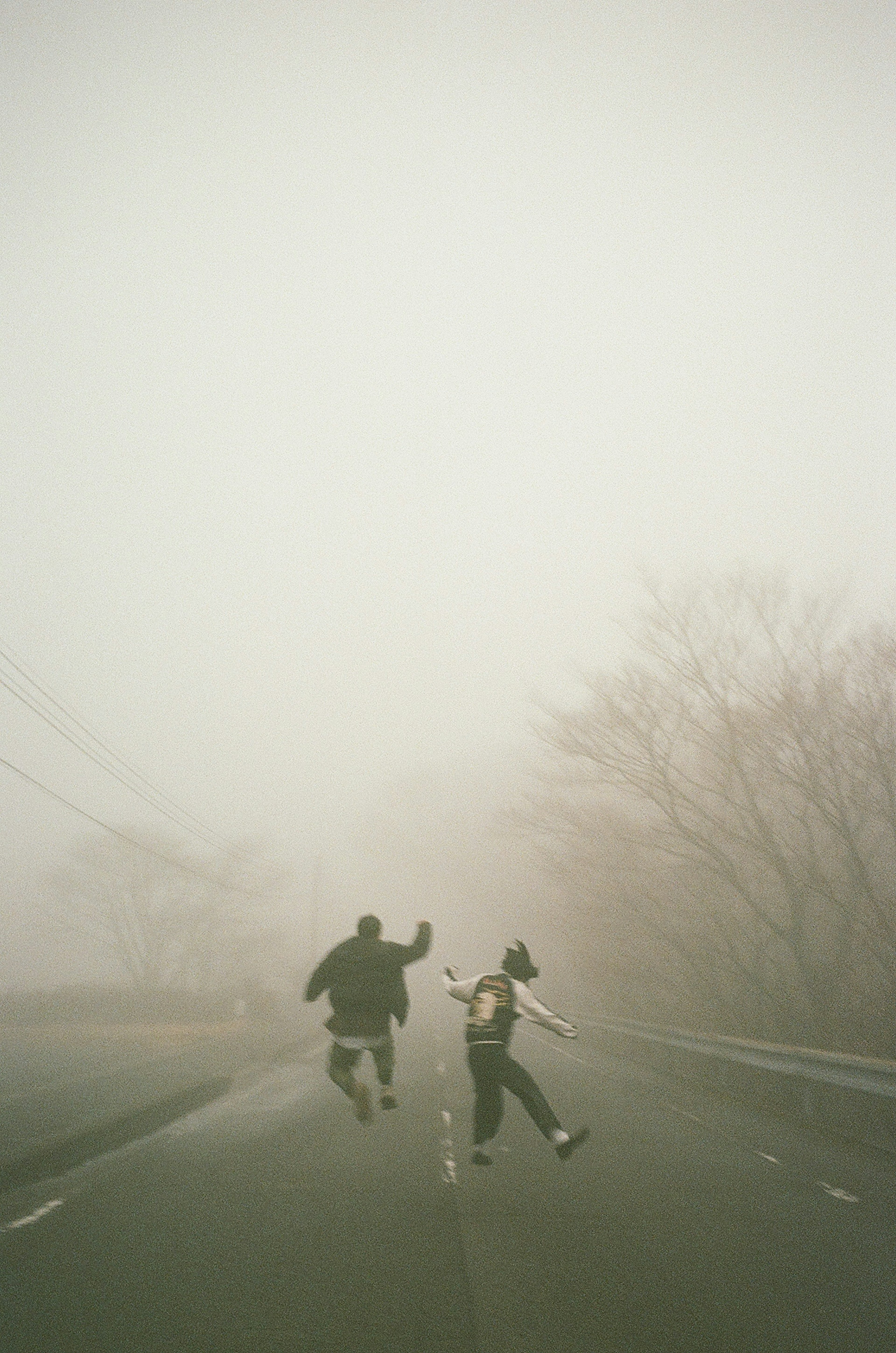 Silhouette di due bambini che corrono nella nebbia