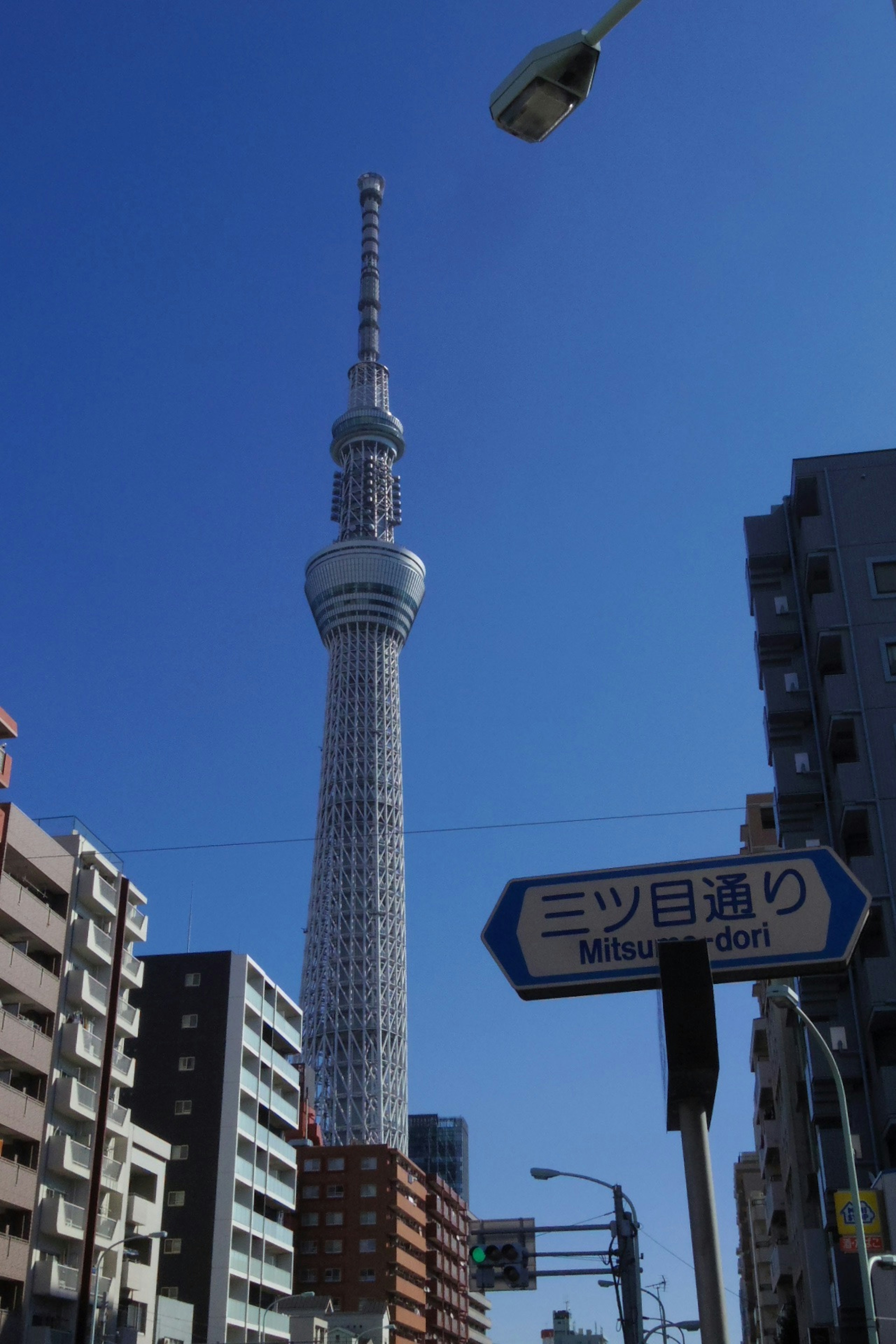 Tokyo Skytree menjulang di bawah langit biru dalam pengaturan perkotaan