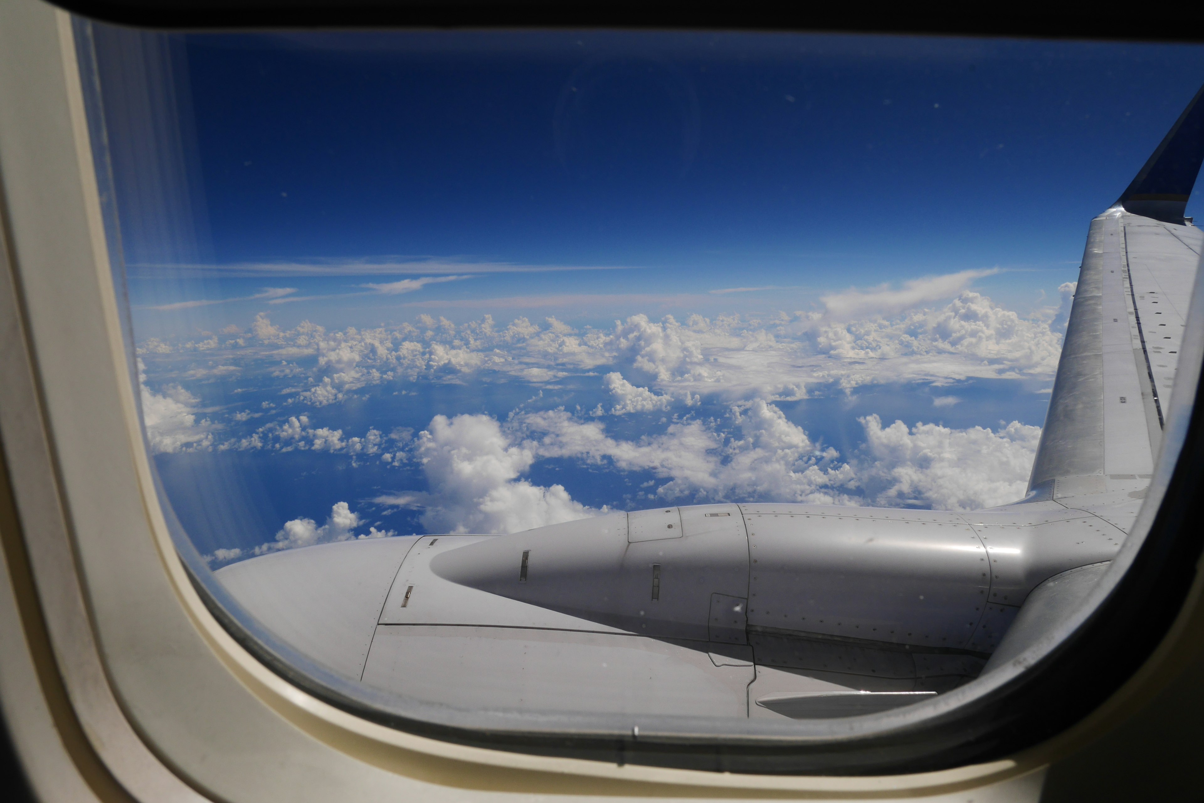 Pemandangan langit biru dan awan dari jendela pesawat