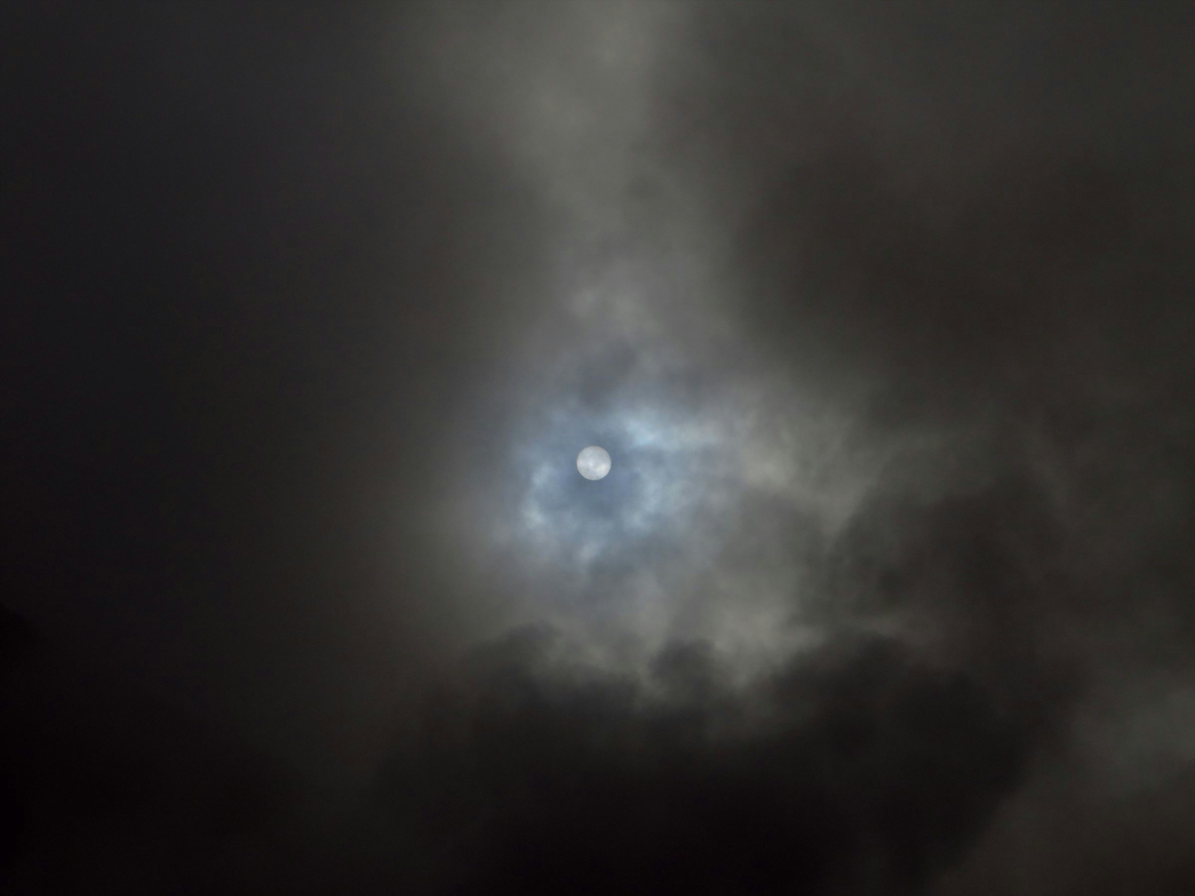 Soleil pâle à travers des nuages sombres