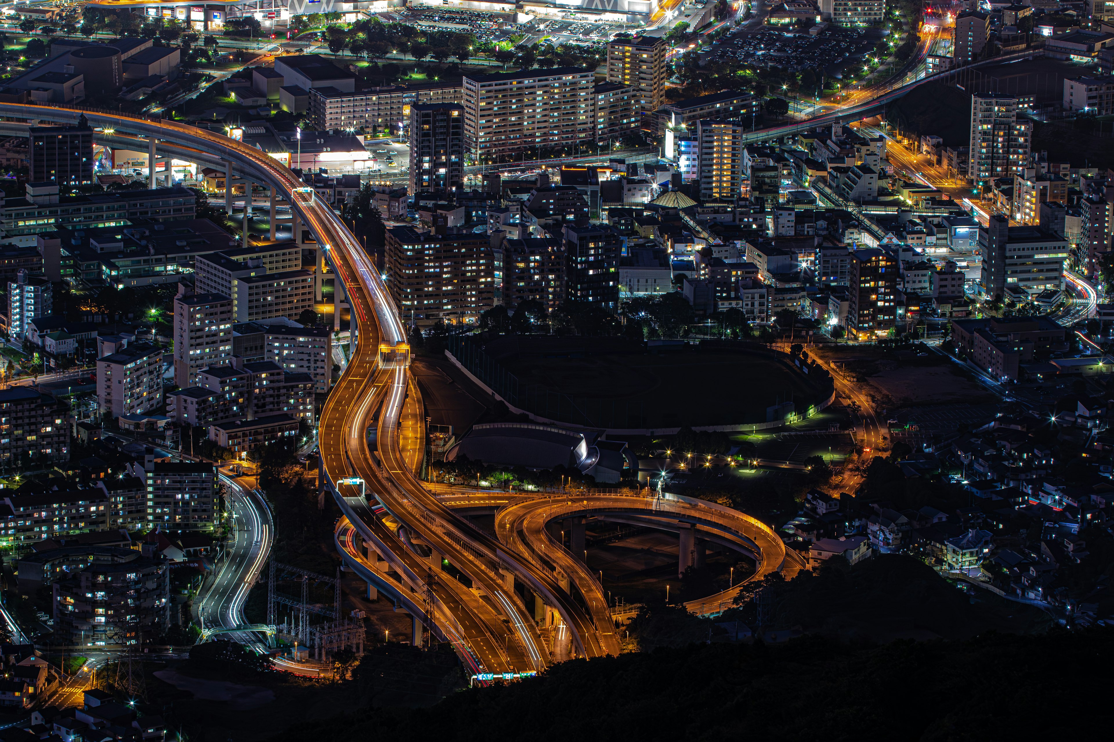 Vista nocturna de una ciudad con intersecciones de autopistas complejas