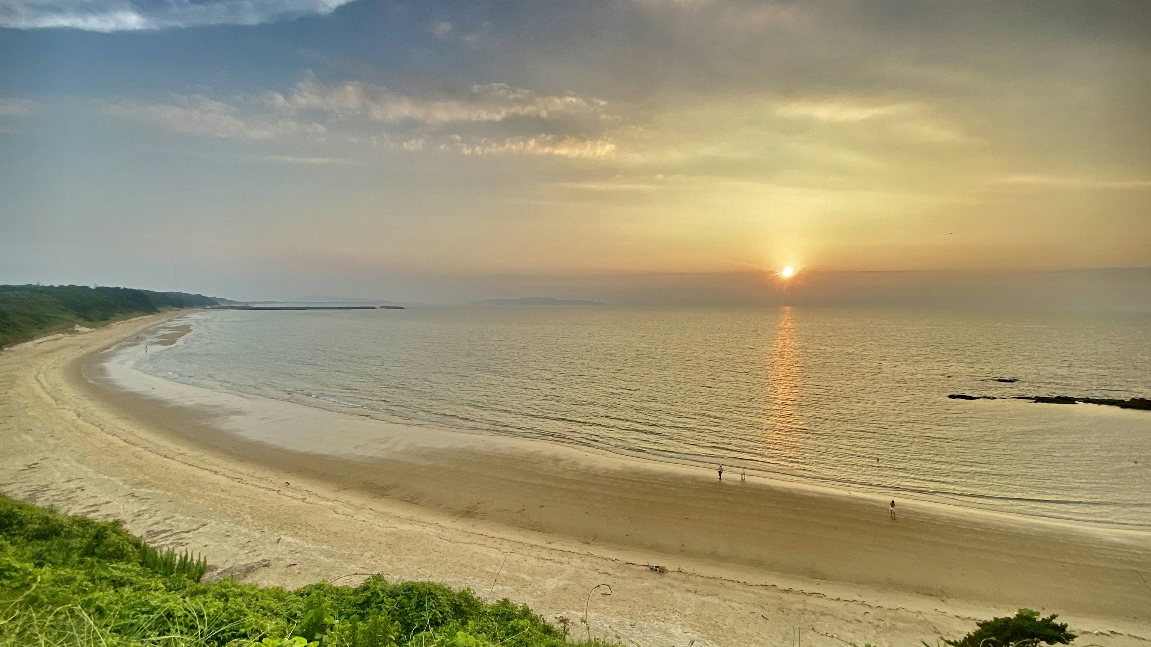 美しい海岸線と穏やかな海の景色に沈む夕日