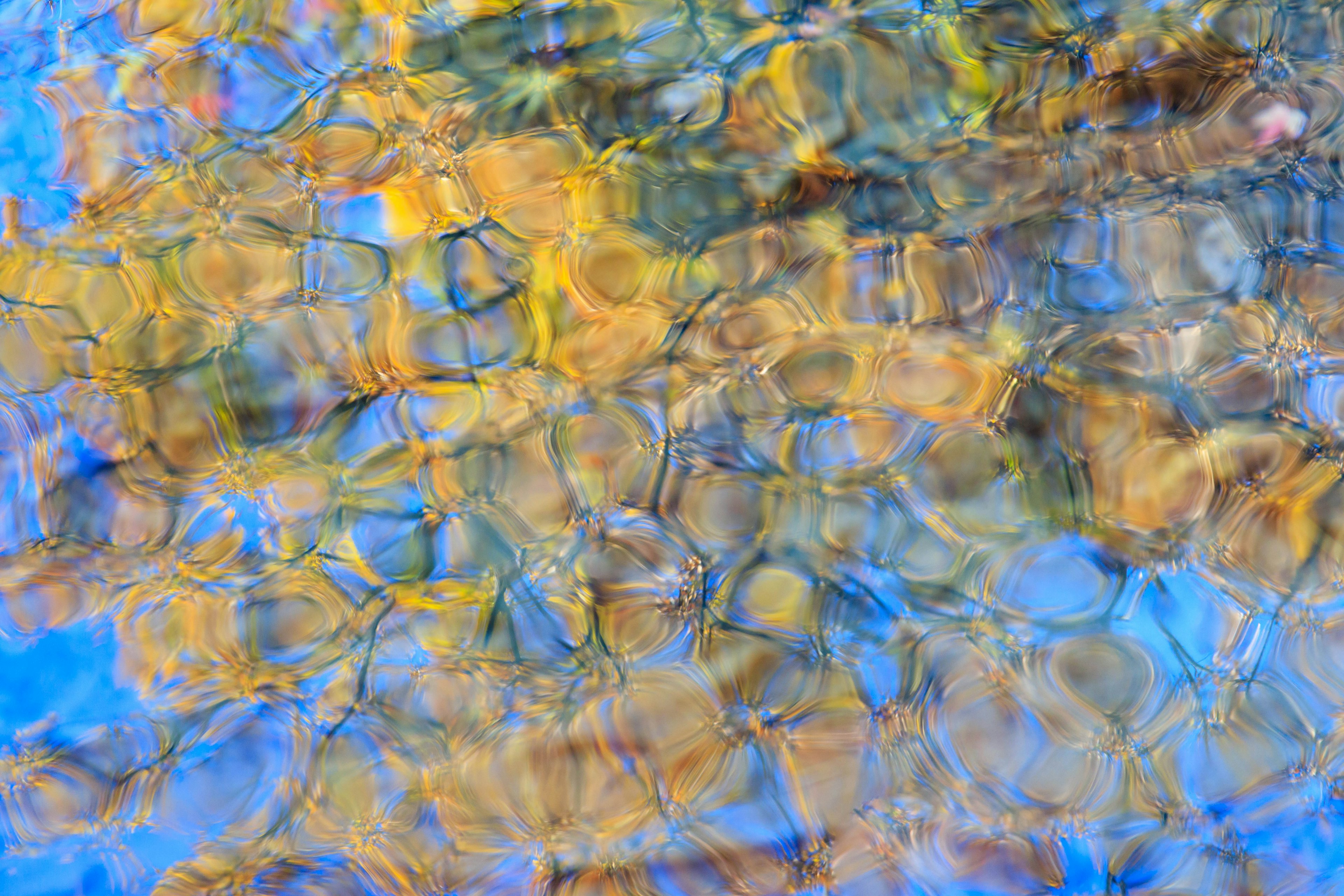 Patrones coloridos de piedras reflejados en la superficie del agua