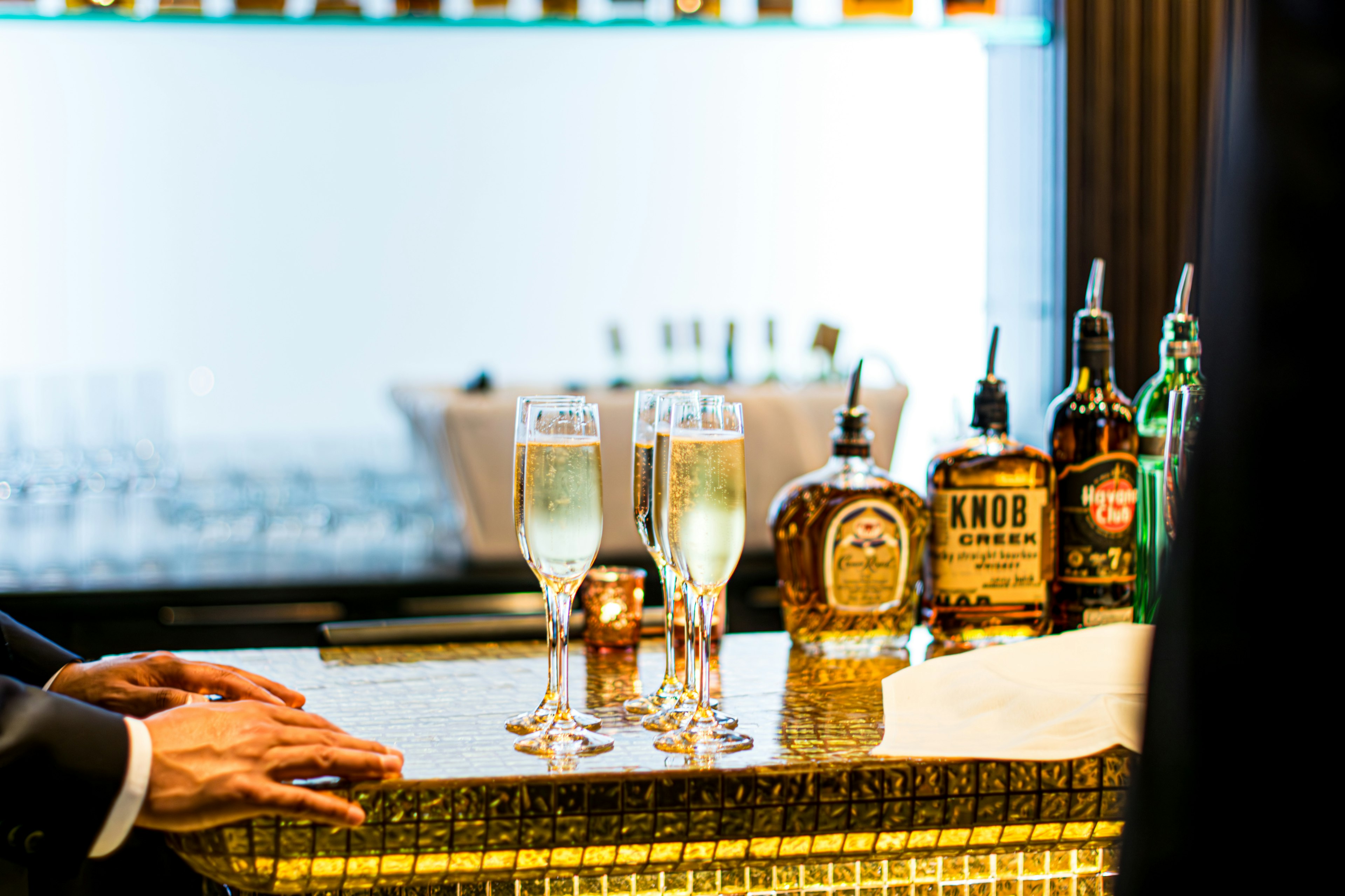 Elegant bar counter featuring champagne flutes and whiskey bottles