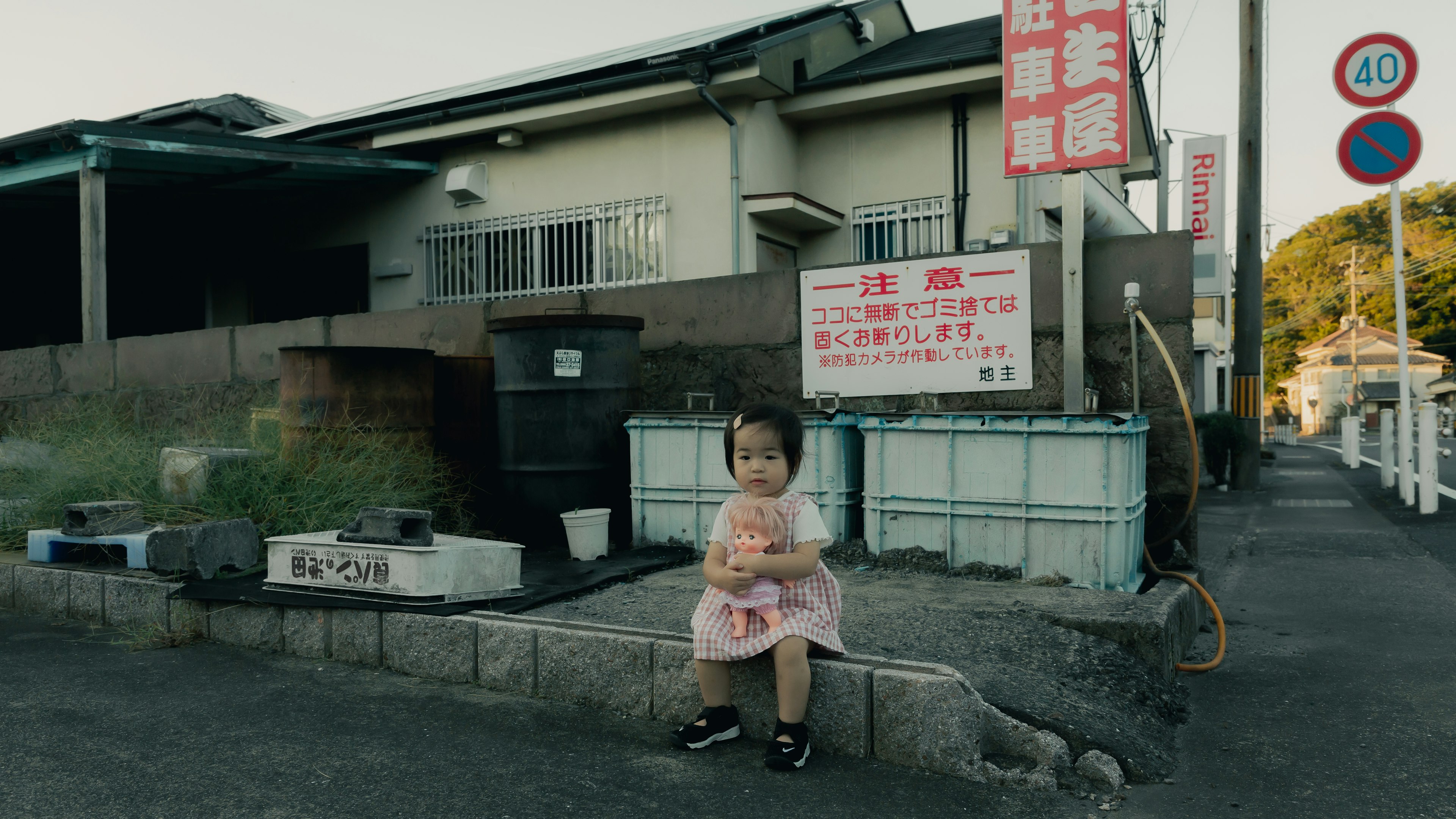 Un petit enfant habillé en yukata assis à un coin de rue