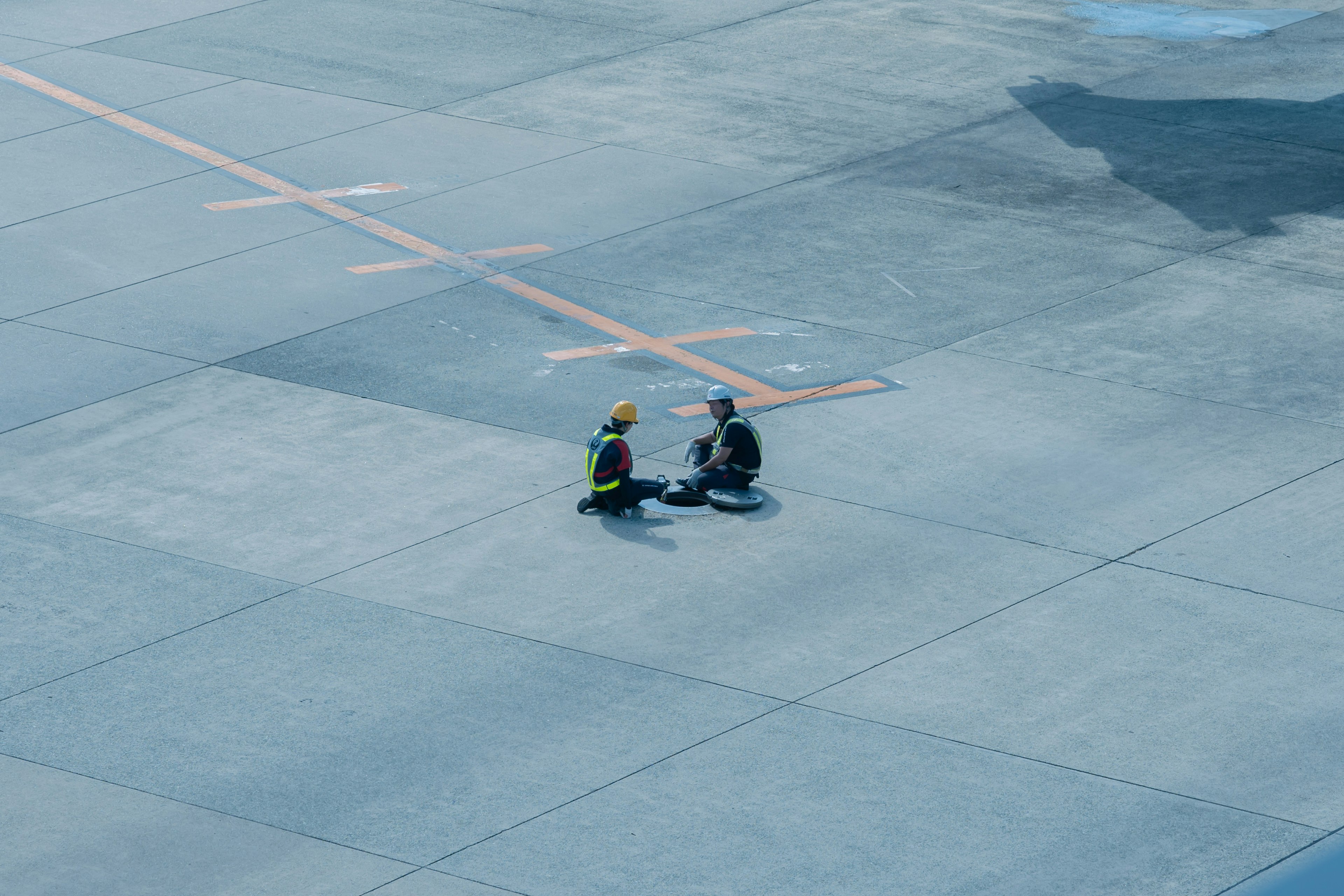 Due lavoratori seduti su una pista d'aeroporto