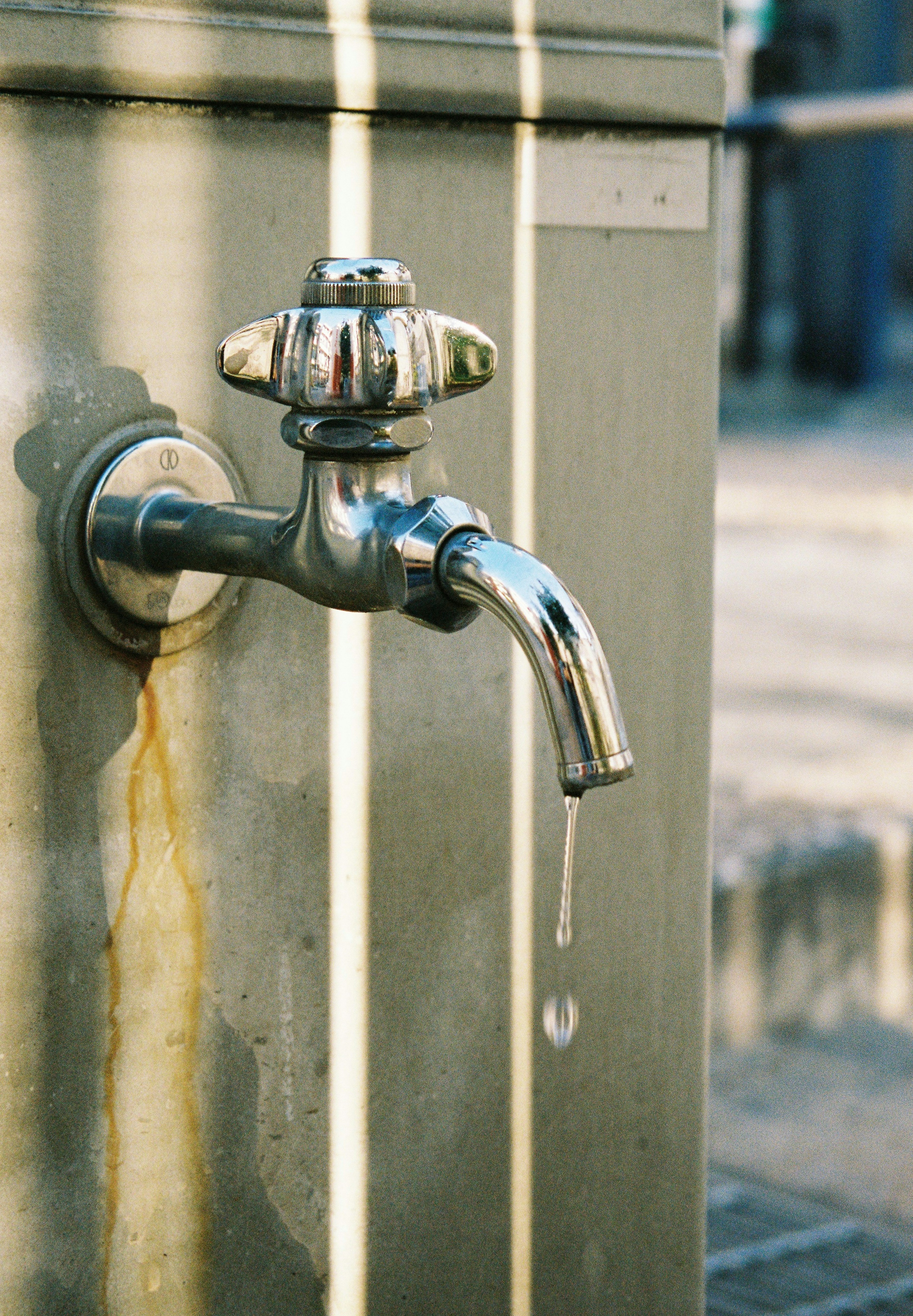 A silver faucet dripping water from a spout