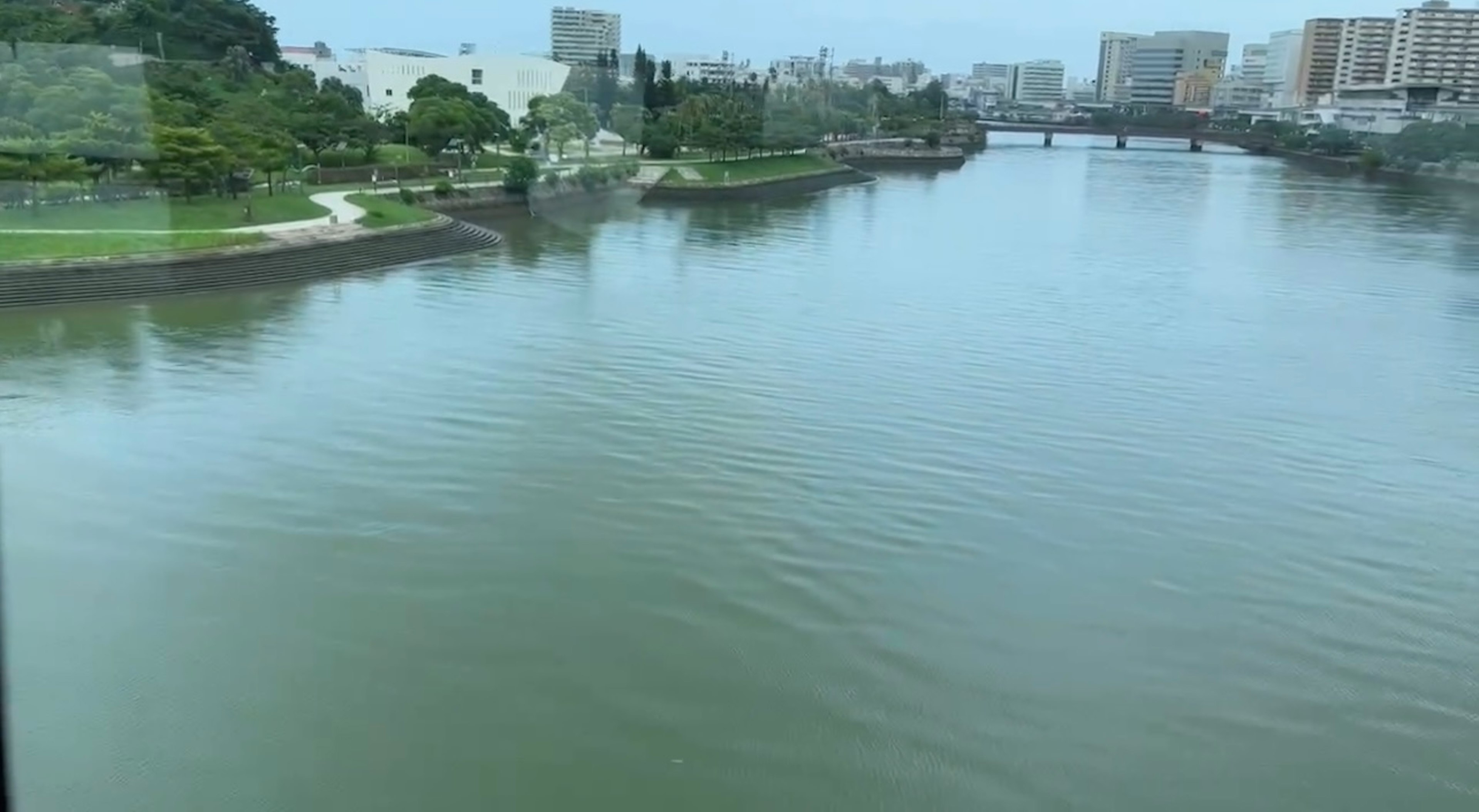 川と都市の風景を映した静かな水面の画像