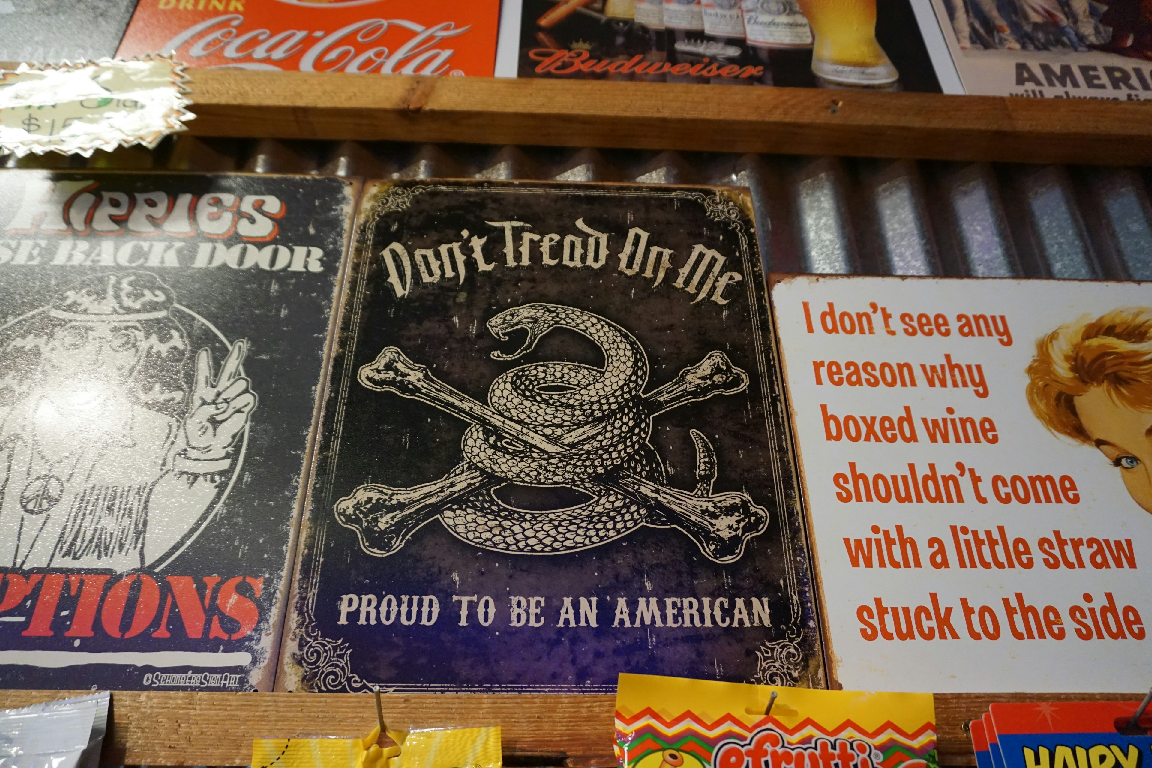 Sign featuring the slogan Don't Tread On Me with a snake and the phrase Proud to Be an American