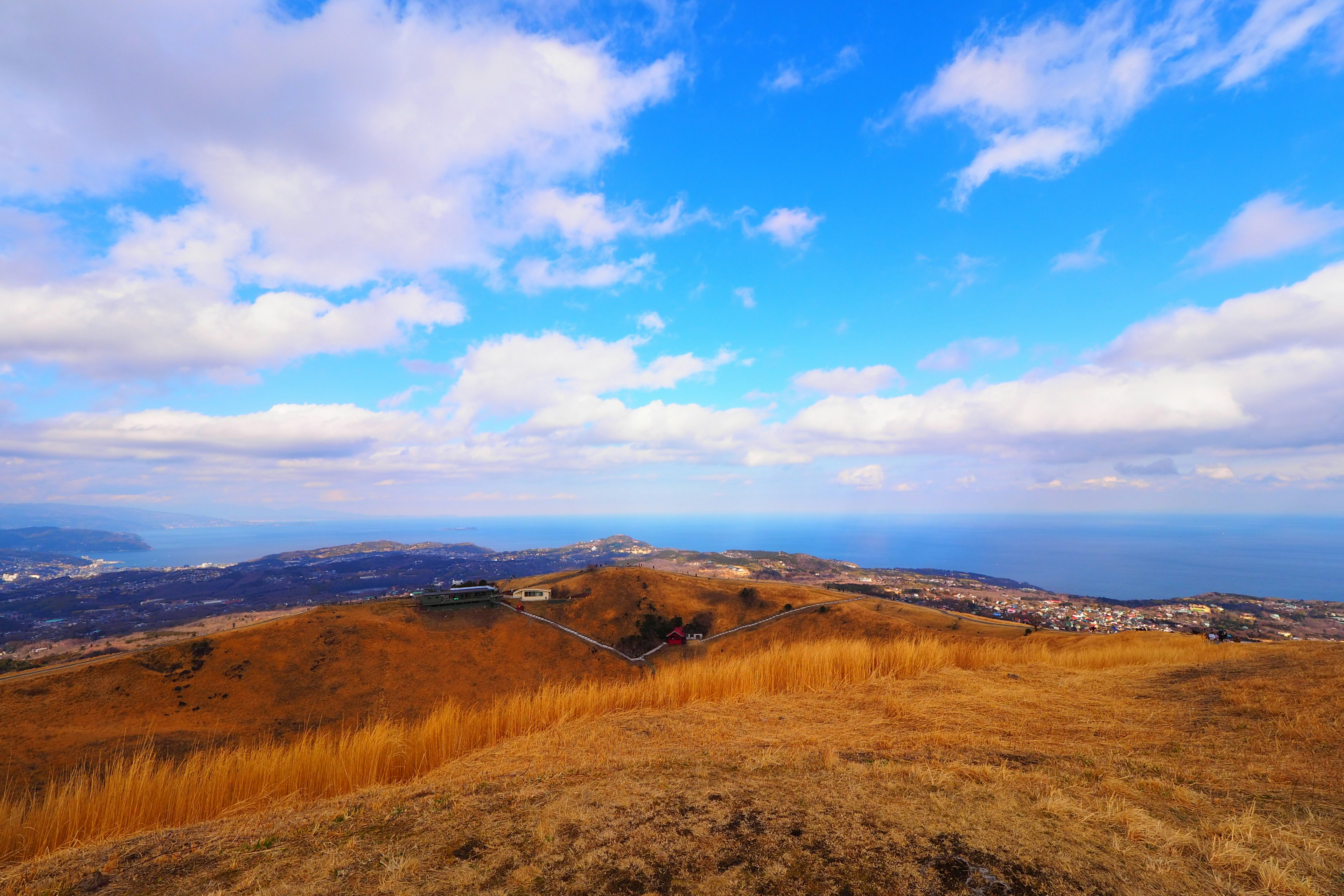 Paesaggio collinare con cielo azzurro e nuvole che sovrasta il mare prateria secca