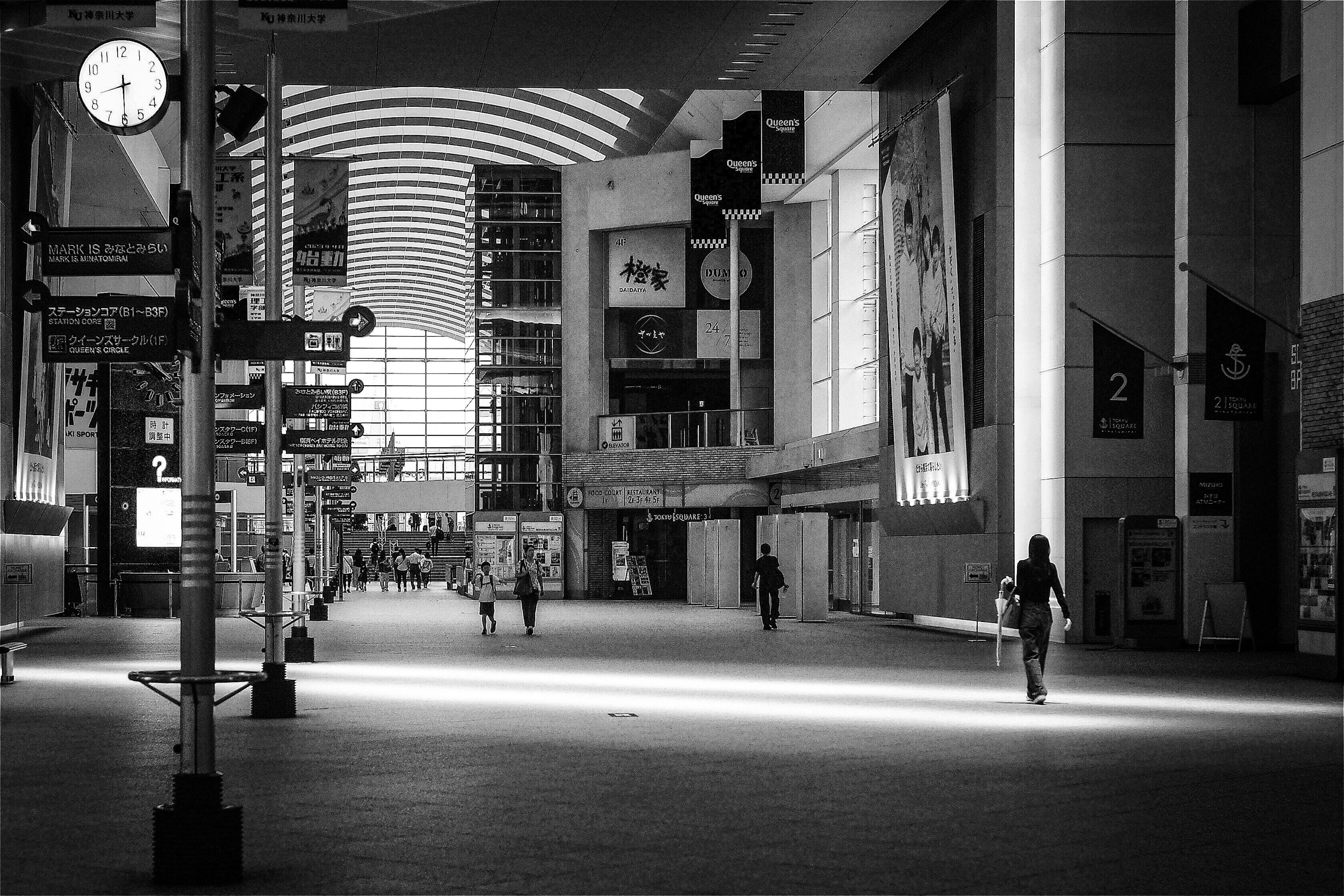 Intérieur d'un espace commercial vide avec des personnes marchant Lumière pénétrant par de grandes fenêtres