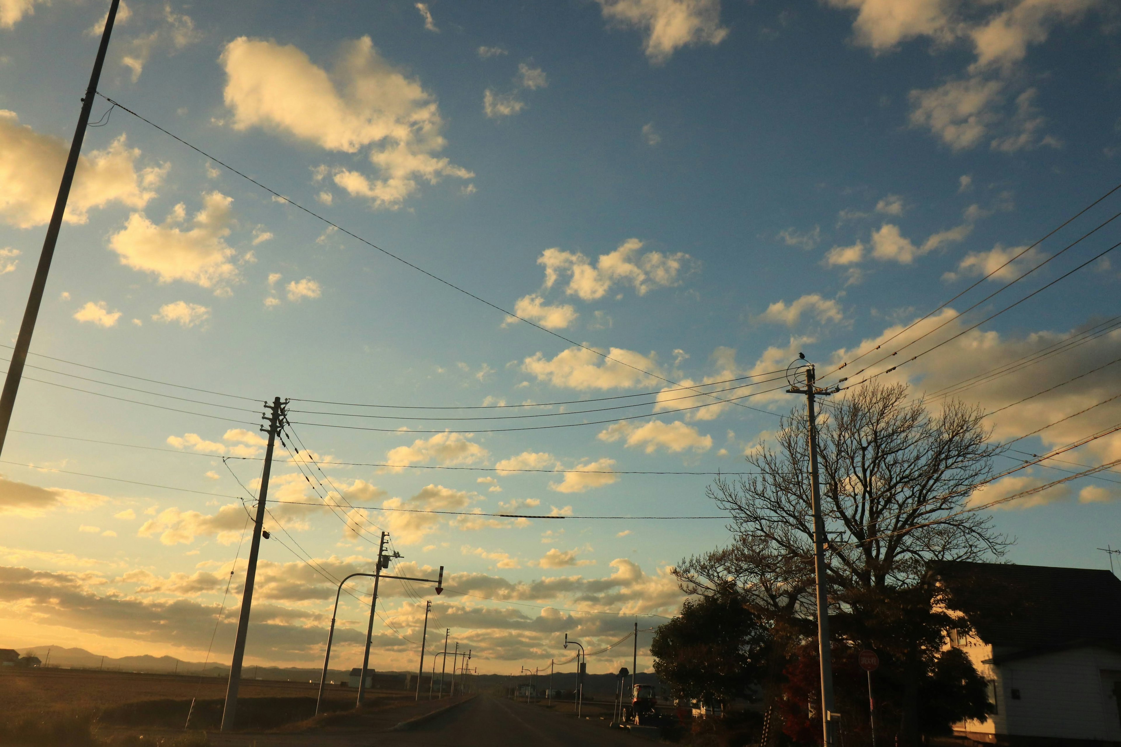 Cielo al atardecer con nubes y vista de la calle