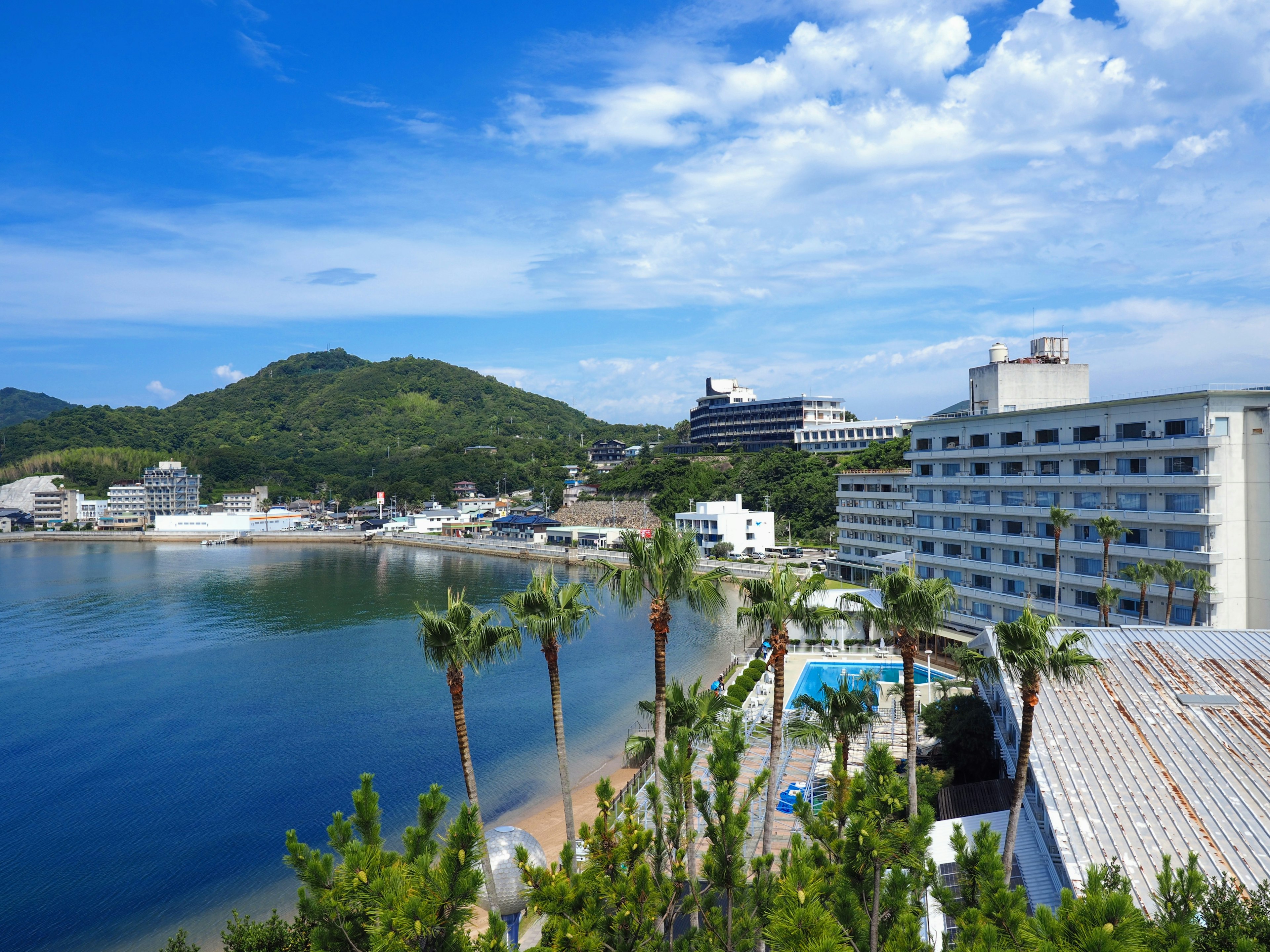 Vista panoramica di un'area resort con mare blu e montagne verdi