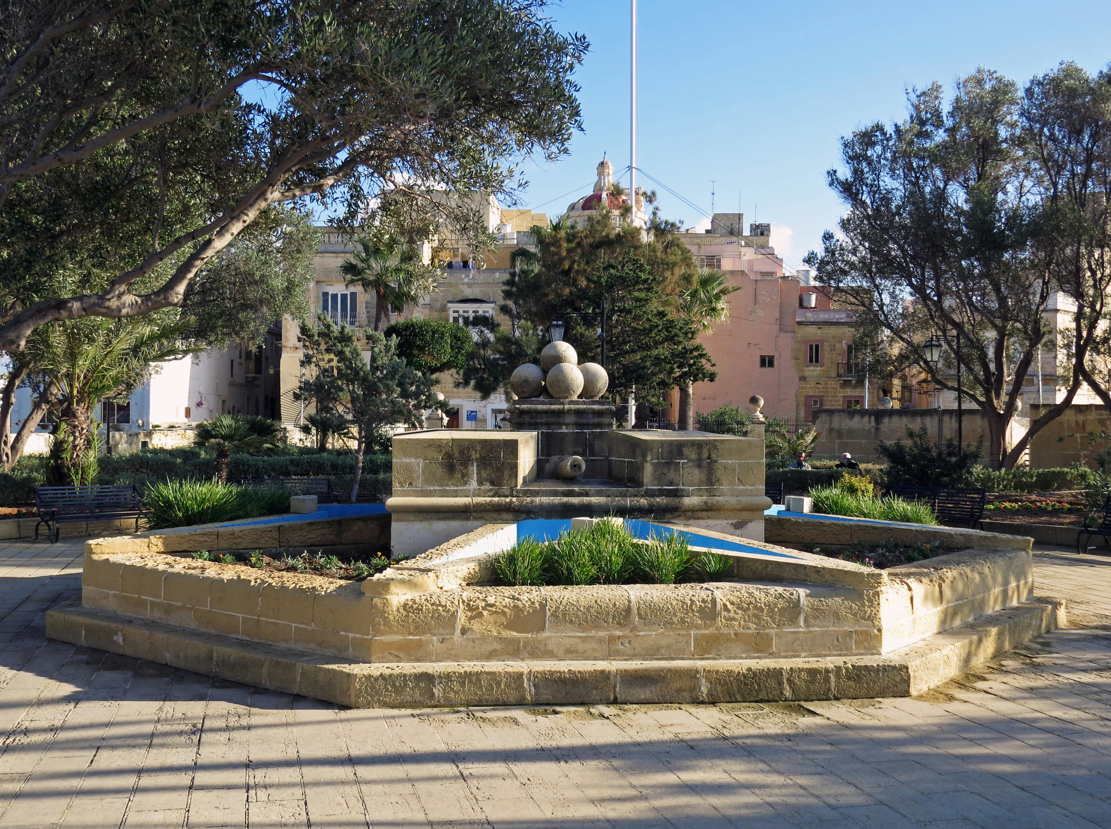 A beautiful park fountain surrounded by lush greenery