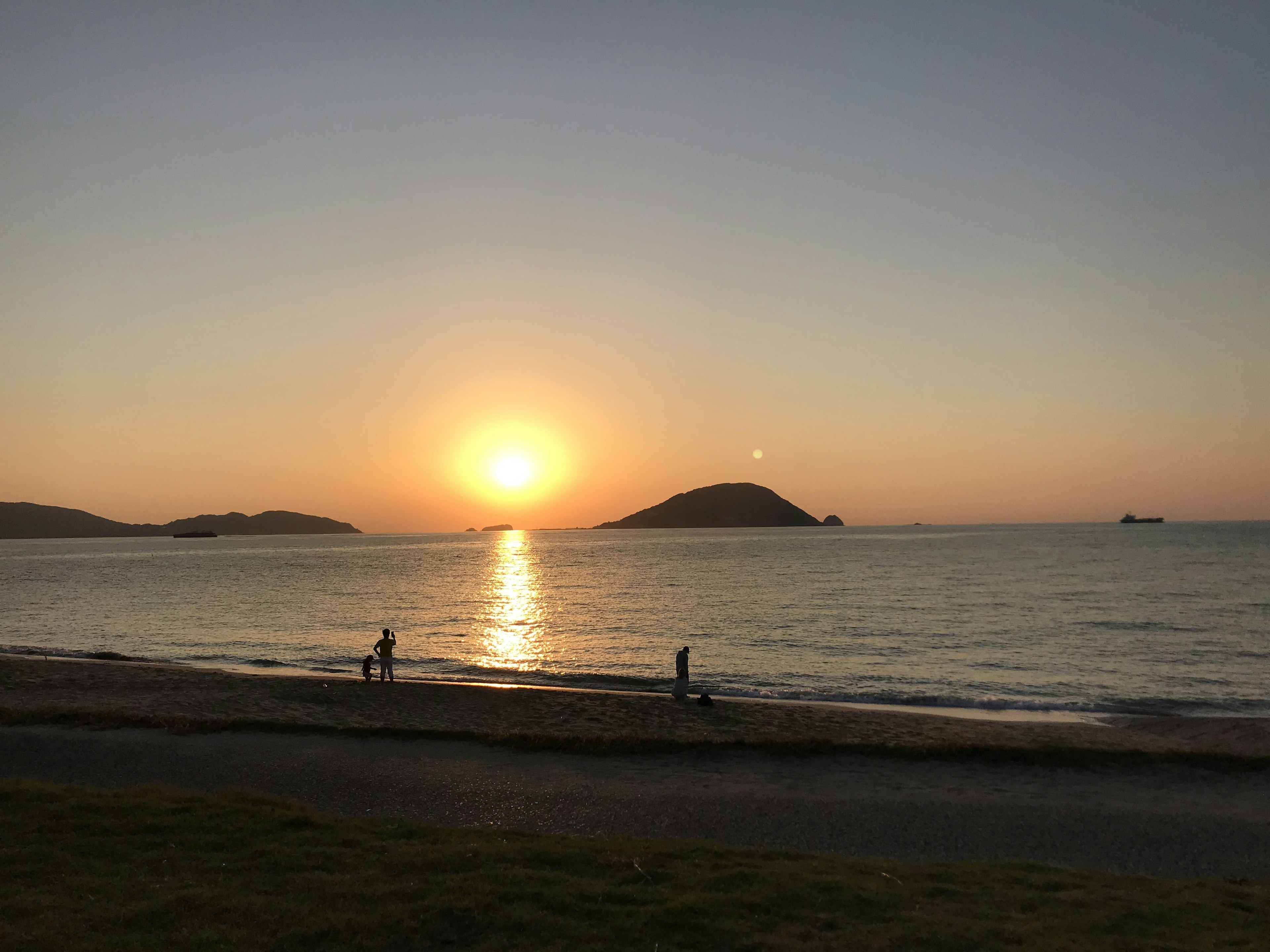 夕日が海に沈む美しい風景と静かなビーチ