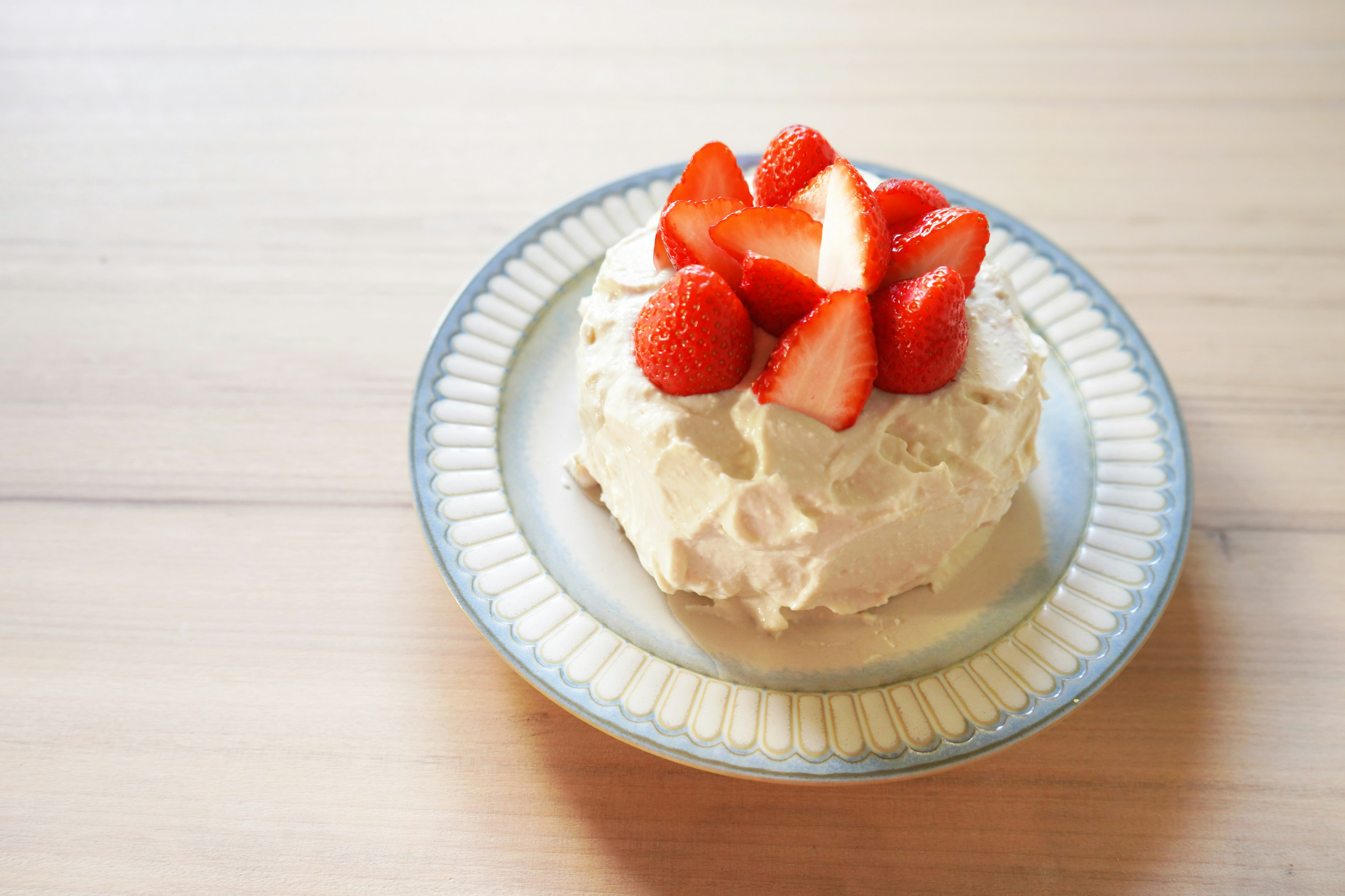 Dessert topped with cream and strawberries on a decorative plate